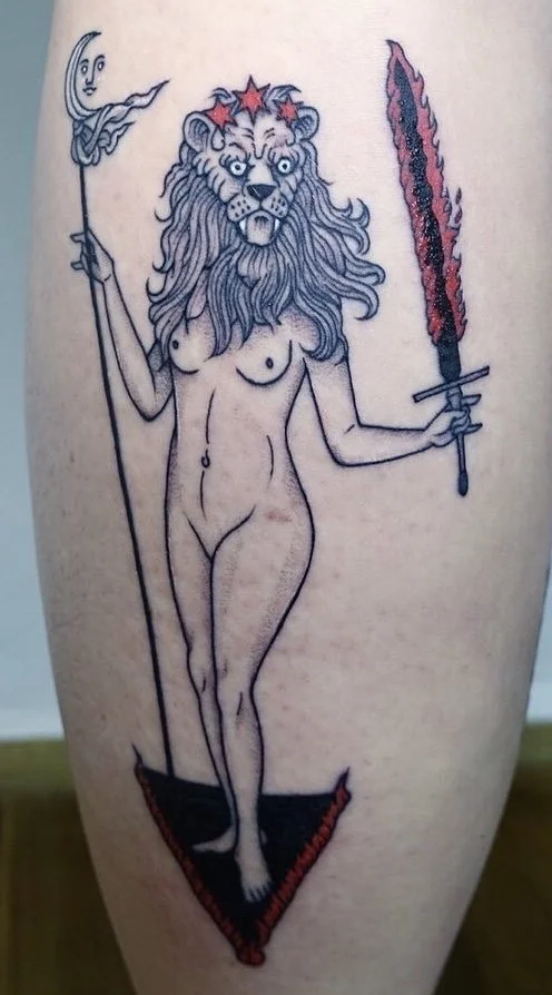 Fineline blackwork tattoo of a lion-headed goddess holding a flaming sword, moon staff, tarot card inspired design