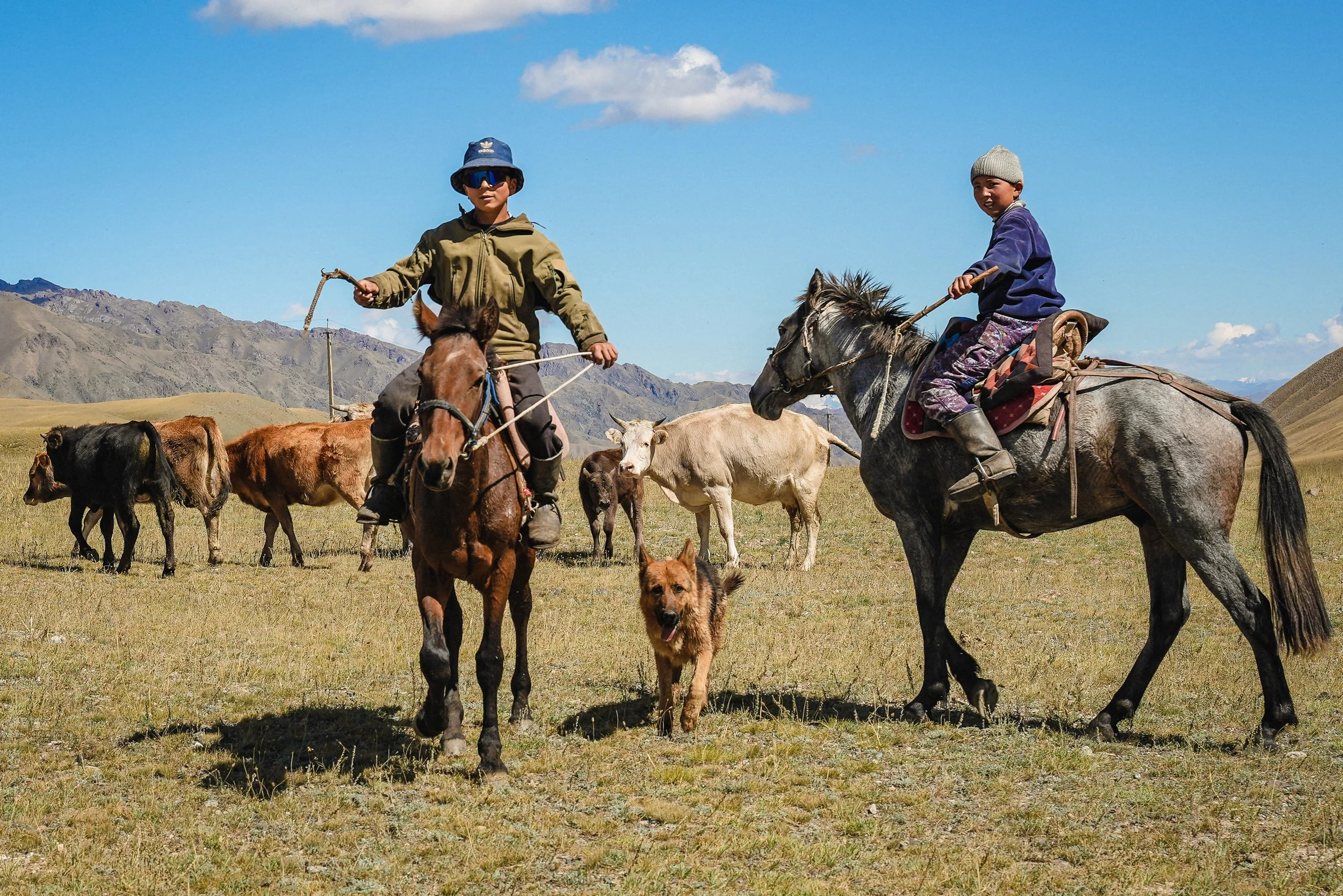 Young Kyrgyz cowboys with their dog en route to Son Kul