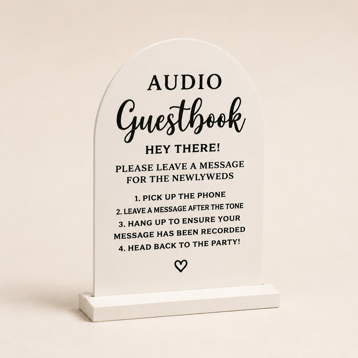 White acrylic sign with black text providing instructions for a guestbook at a party. The sign states 'AUDIO Guestbook' and offers steps for guests to leave messages on a phone, including picking up the phone, leaving a message, hanging up, and returning to the party.