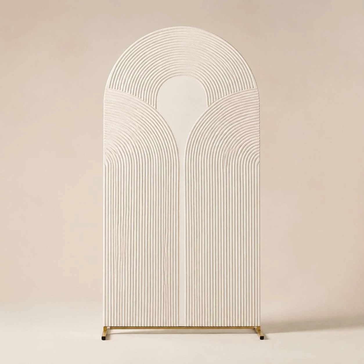A modern decorative room divider with a minimalist, arched design made of white, evenly spaced vertical and curved lines on a beige background.