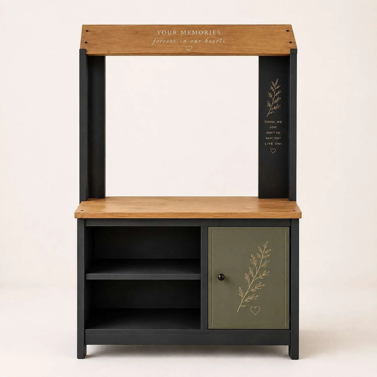 A black and wood-colored shelving unit with a top, middle, and bottom sections, decorated with engraved botanical and heartfelt messages.