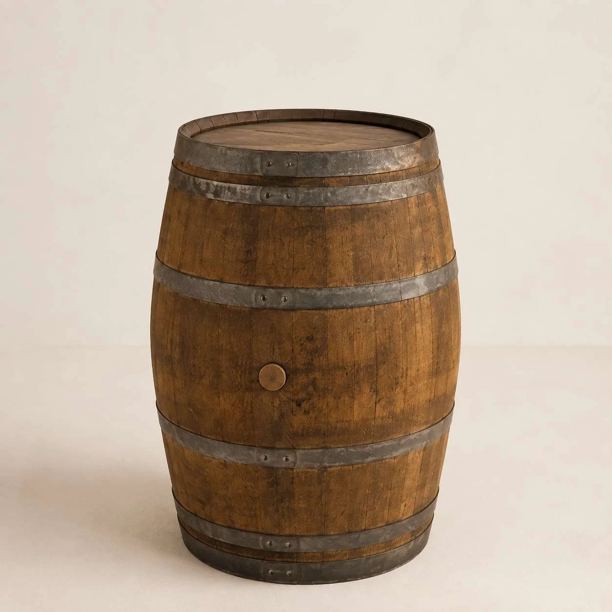 A wooden whiskey barrel with metal hoops on a plain light background.