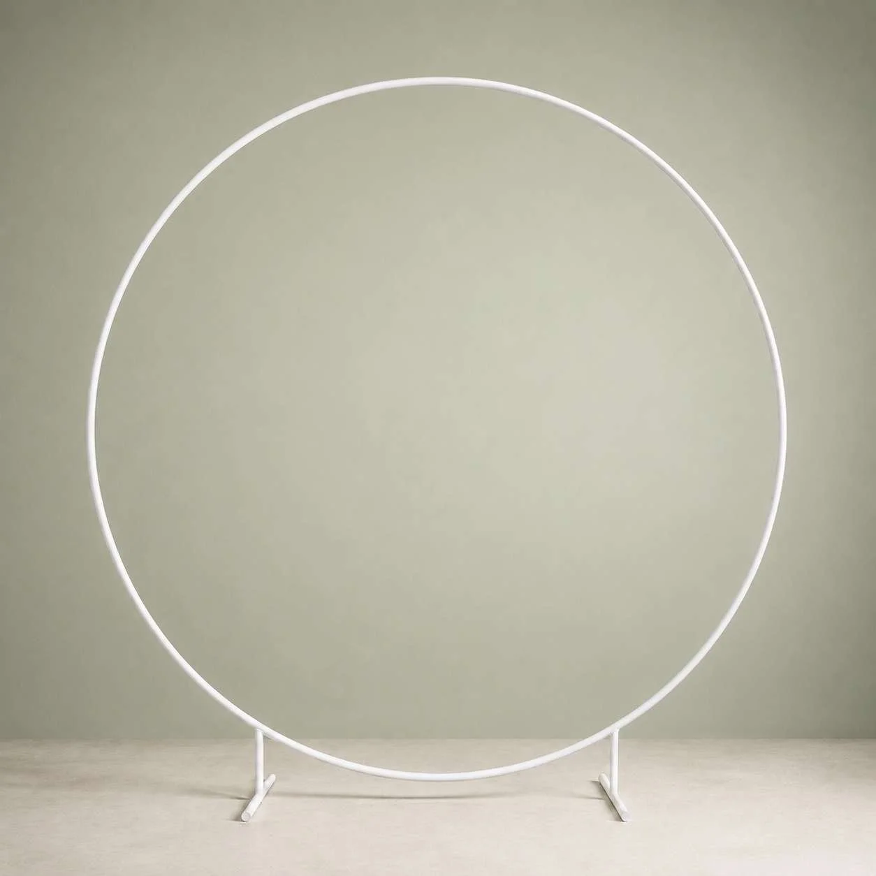 Minimalist white circular sculpture with two vertical supports on a light-colored surface.