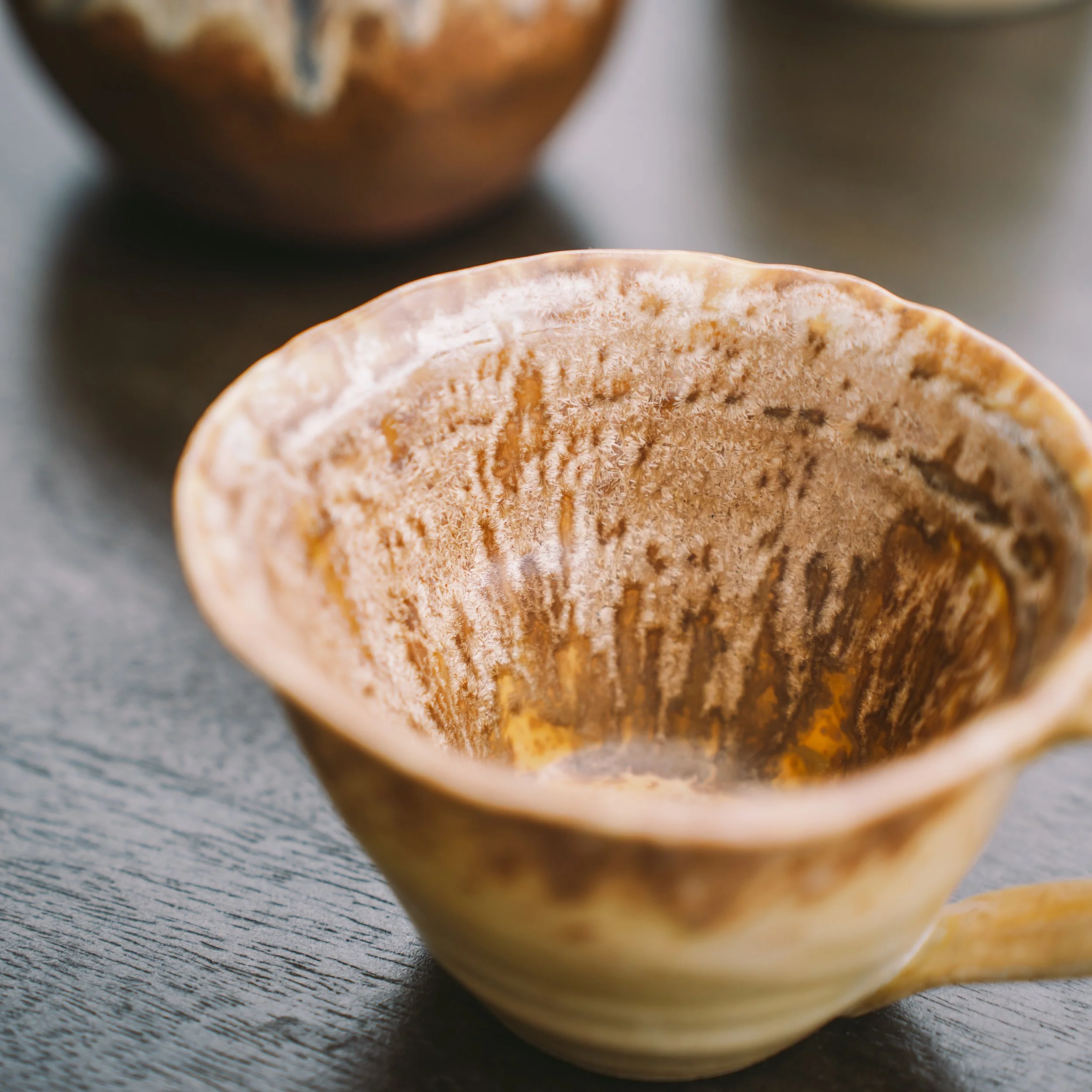Close-up of a partially sliced orange on a dark textured surface.