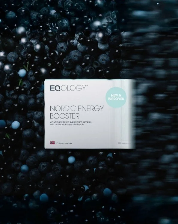 Een doos supplementen genaamd EQOLOGY Nordic Energy Booster ligt op een bedje van bosbessen.