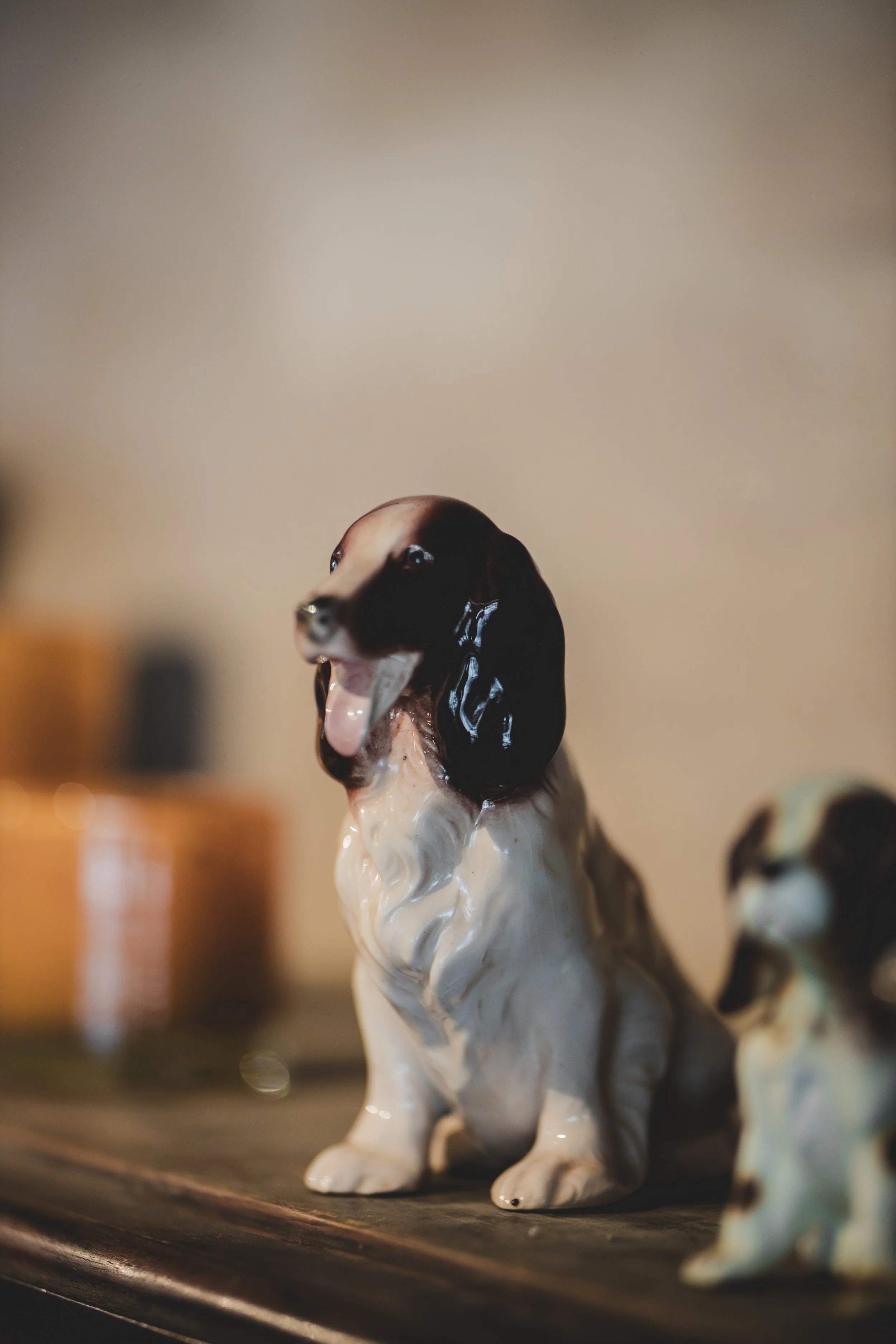 Porcelainsfigur av en springande hund med svart och vitt mönster, placerad på en träyta.