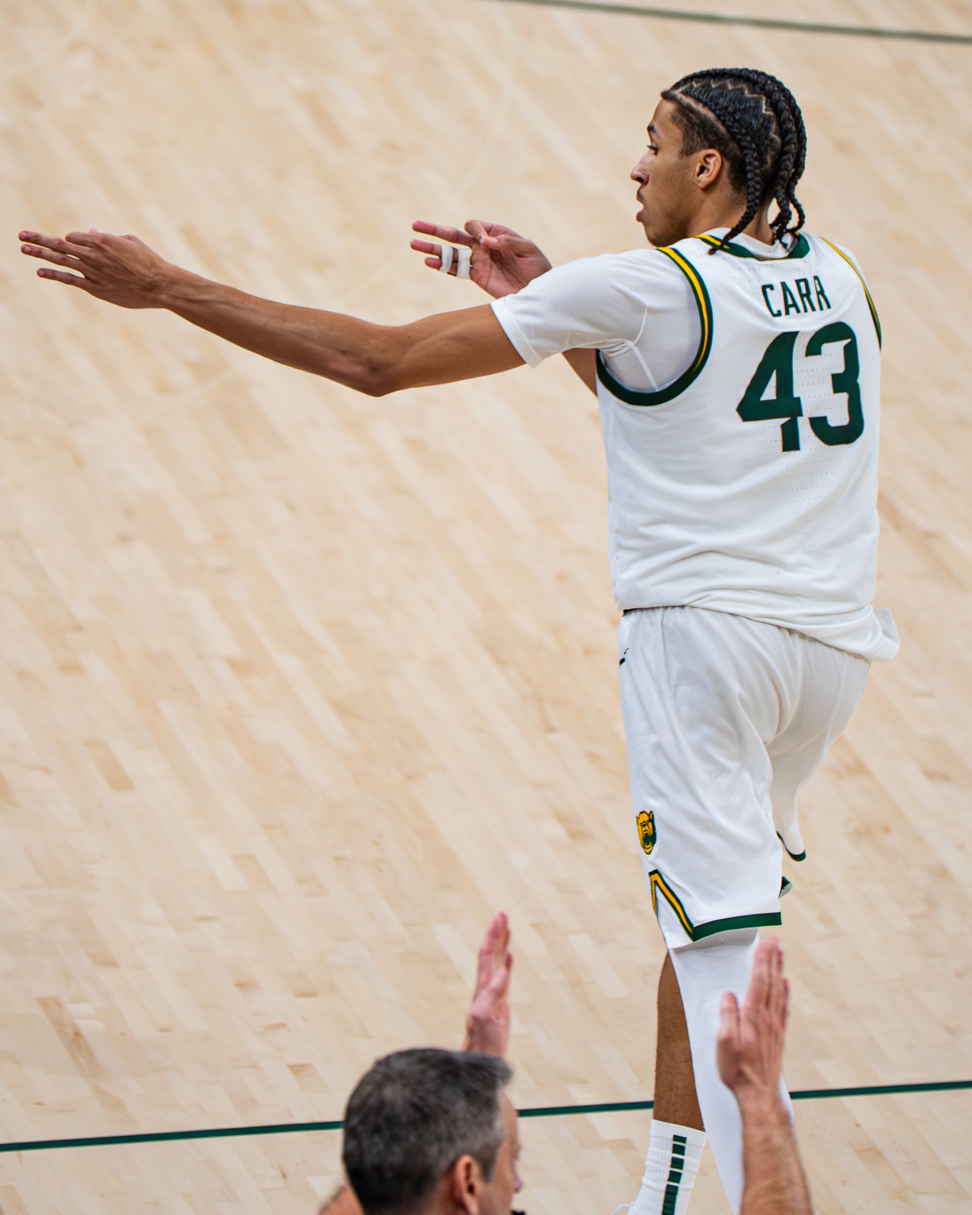 Basketball player with jersey number 43, named Carr, on a basketball court, reaching out with one arm while another person gestures towards him.