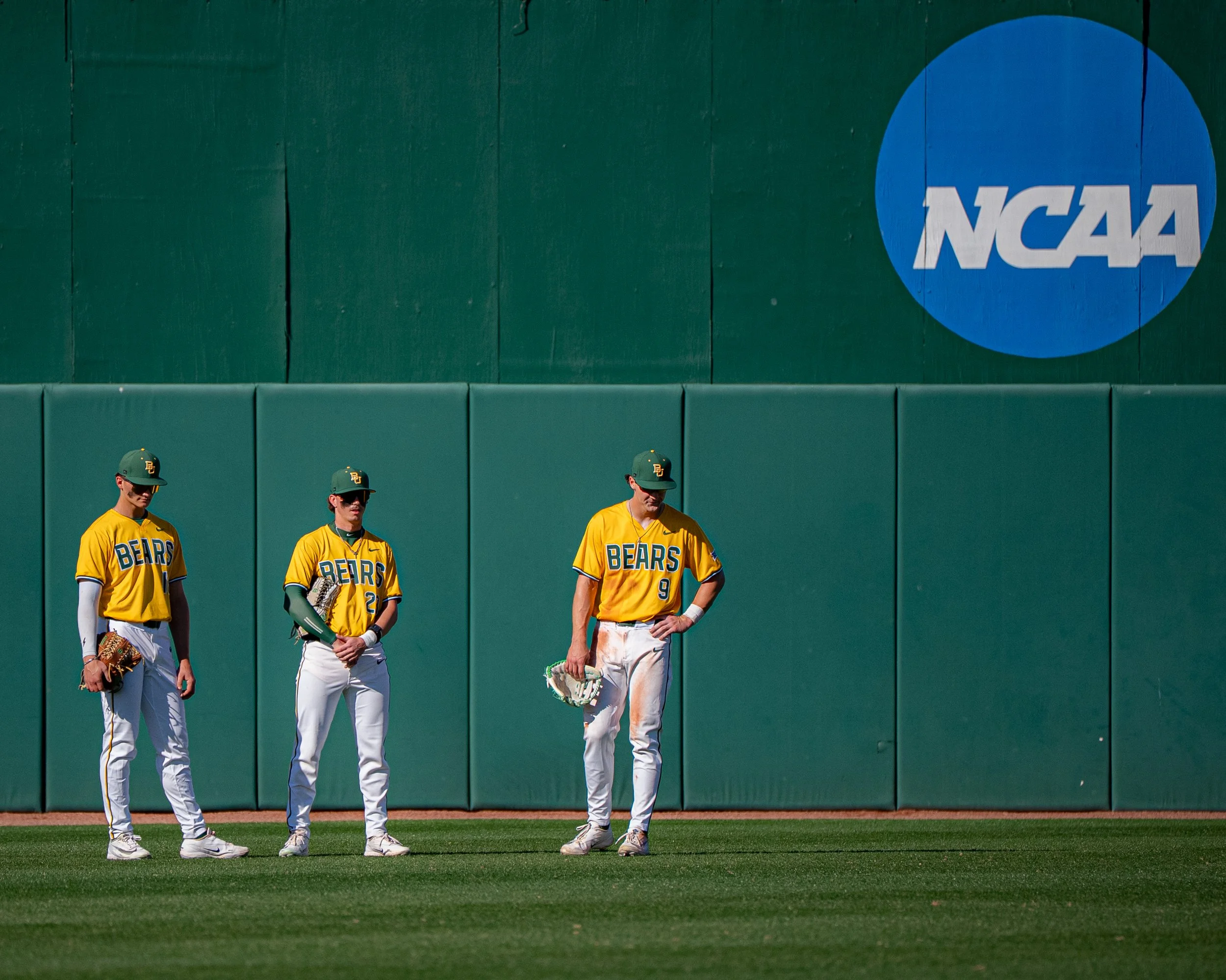 Four baseball players in yellow jerseys with 