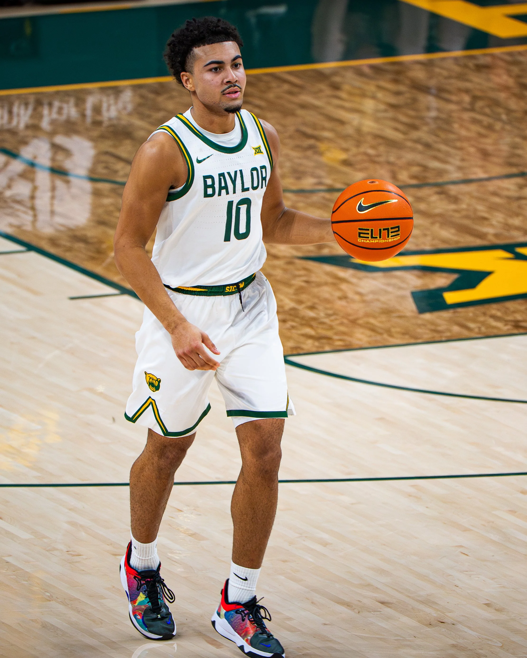 A basketball player from Baylor University holding an orange Spalding basketball on a wooden court.