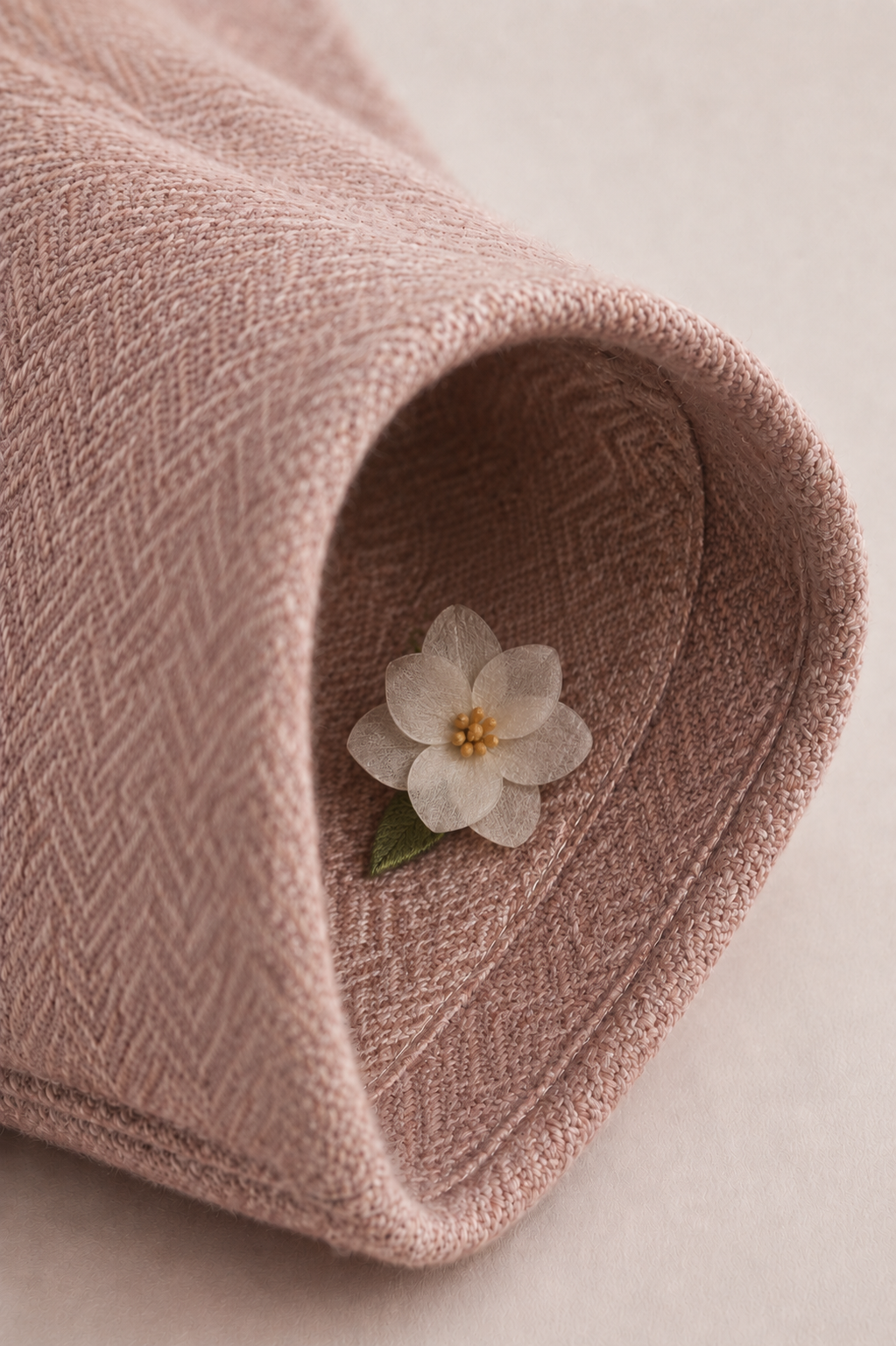 Handcrafted blossom nestled inside the rolled sleeve of the Nenúfar Bloom wool coat.