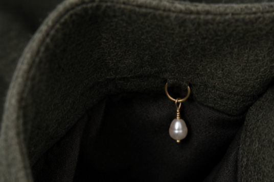 Close-up of the Moss coat, featuring one of Nenúfar's signature handcrafted details.
