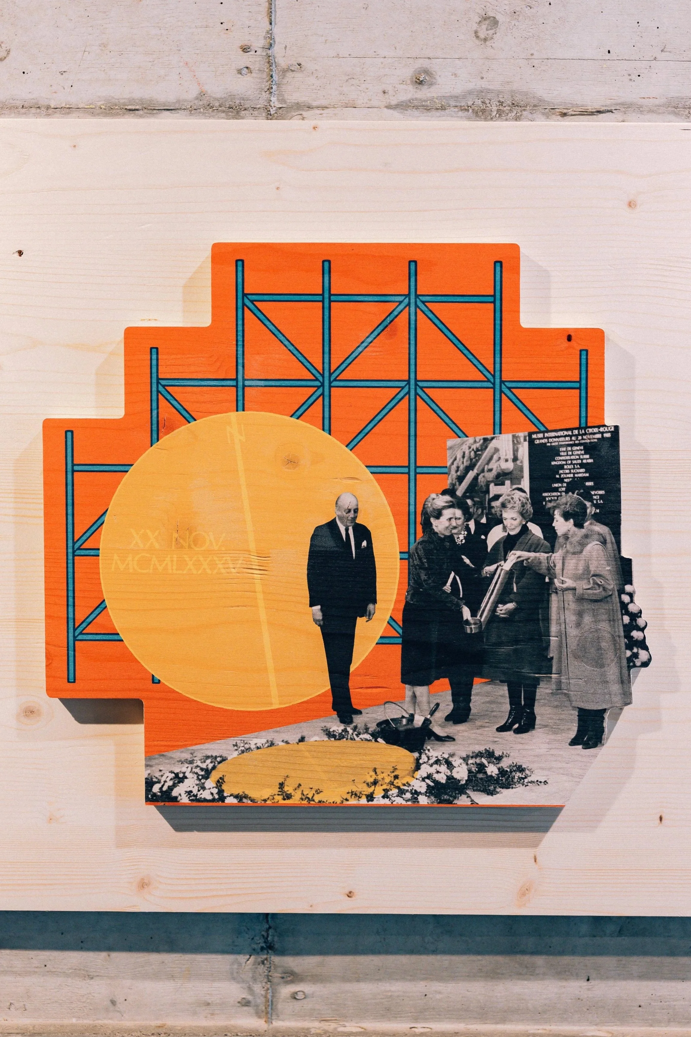 Photo d'une affiche ou d'un panneau illustrant des personnes en discussion, dont un homme en costume et plusieurs femmes, devant un fond orange avec des éléments graphiques et un cercle jaune. Il y a aussi une photo en noir et blanc d'un groupe de personnes au bas de l'affiche.