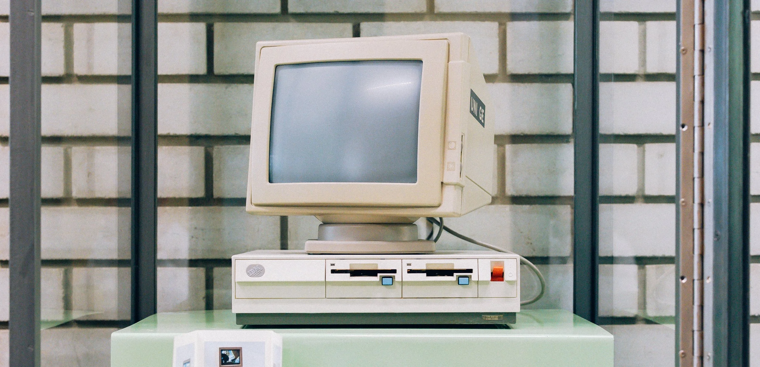 Un ordinateur vintage de style rétro sur une étagère, avec un écran CRT beige.