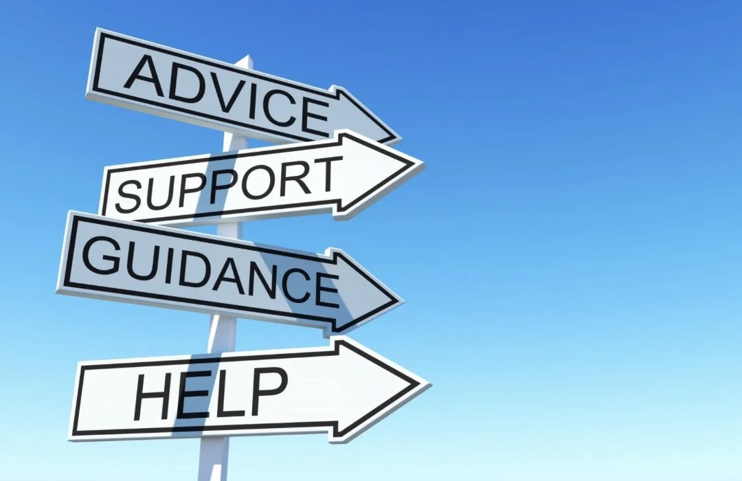 Straßenschilder mit den Worten 'Advice', 'Support', 'Guidance' und 'Help' gegen blauen Himmel