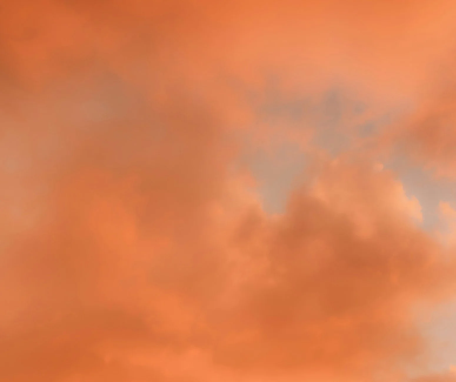 Der Himmel ist bedeckt mit orangefarbenen Wolken, die eine stimmungsvolle Atmosphäre erzeugen.