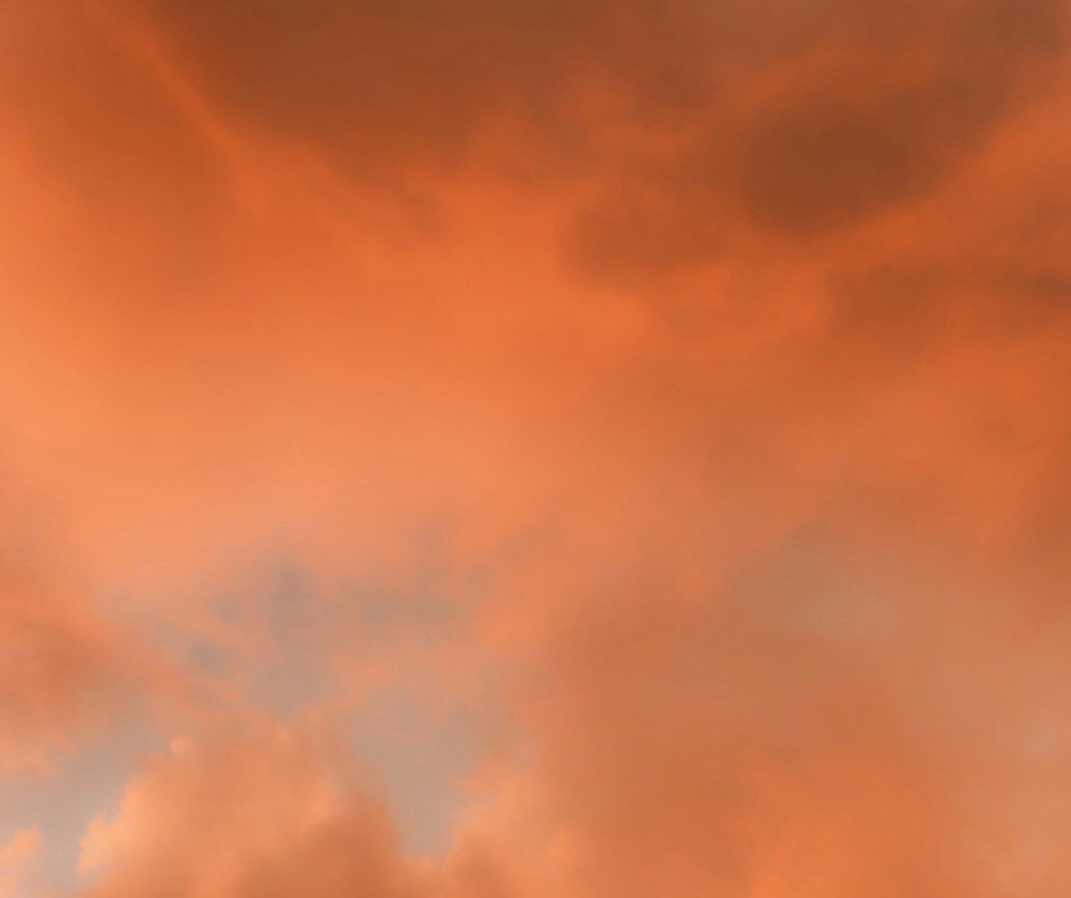Ein orangefarbener Himmel mit dunklen Wolken.