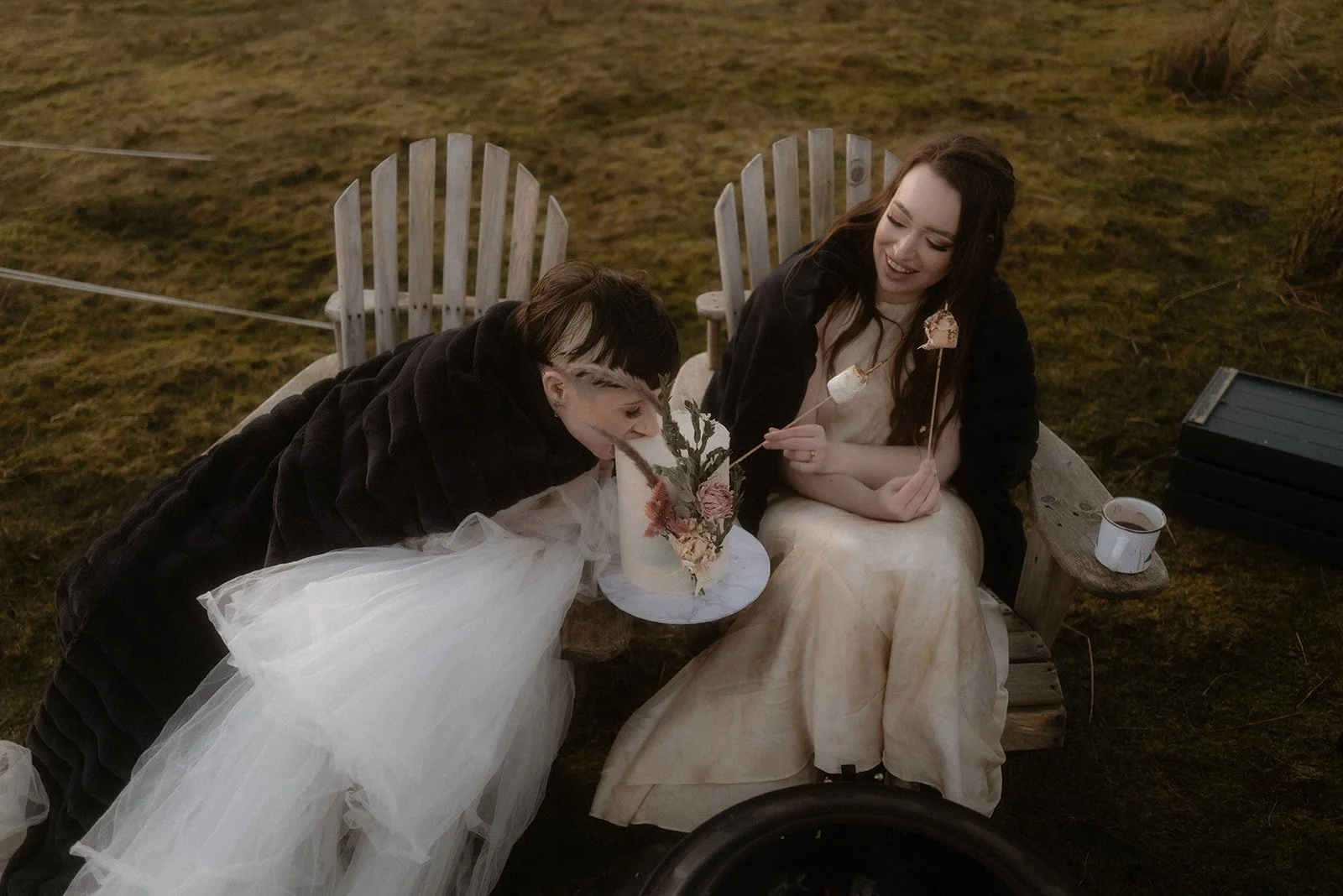 Couple having fun together and enjoying their wedding cake after their elopement at the Quiraing, Isle of Skye.