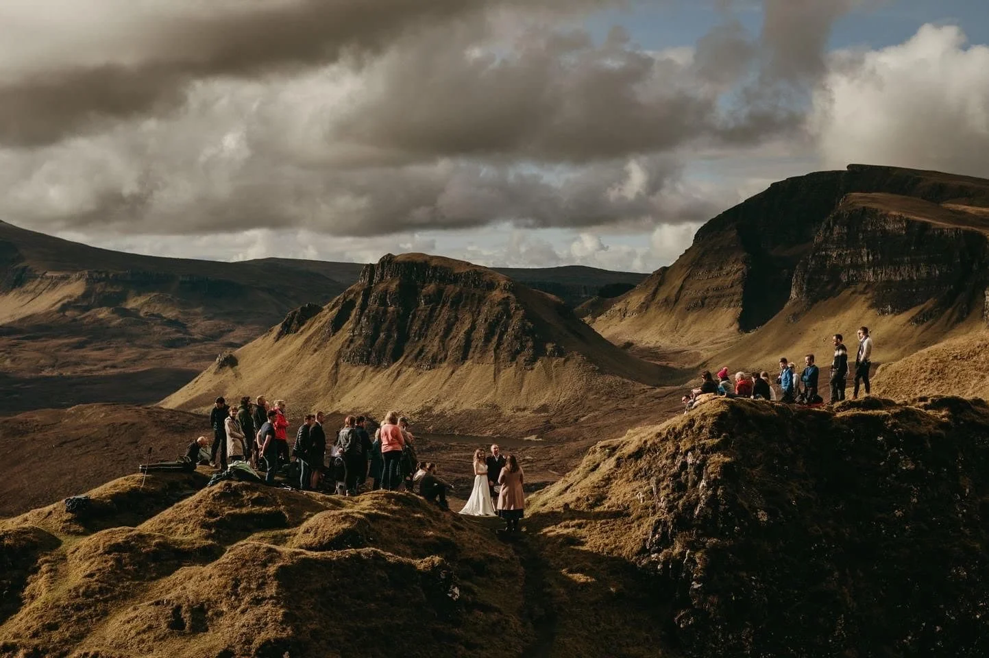 Bride and groom celebrating with guests on the Quiraing, Trotternish Ridge, Isle of Skye, surrounded by dramatic mountain scenery.