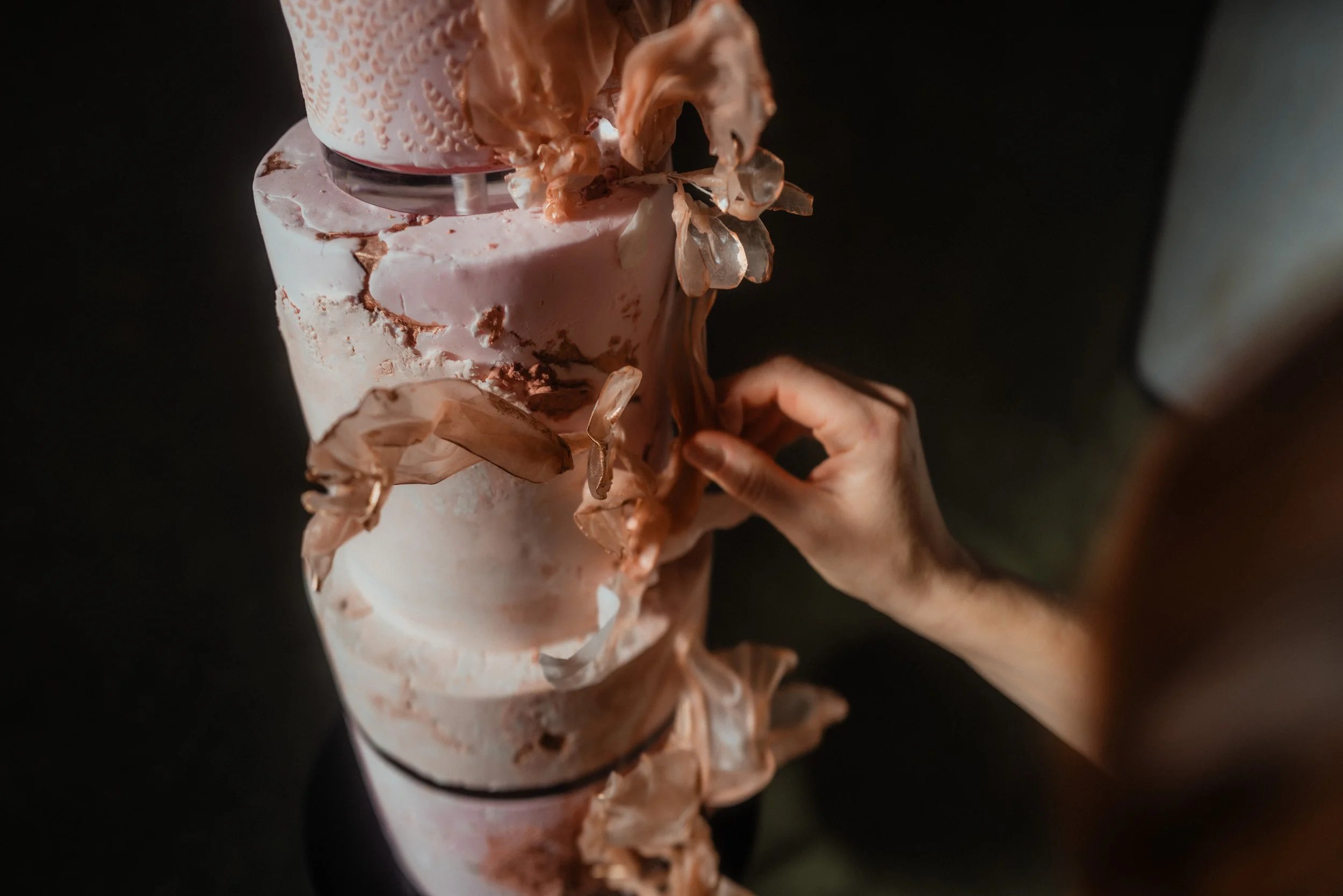 Close-up of a luxury wedding cake featuring handmade rice paper, textured finishes and artistic botanical details.