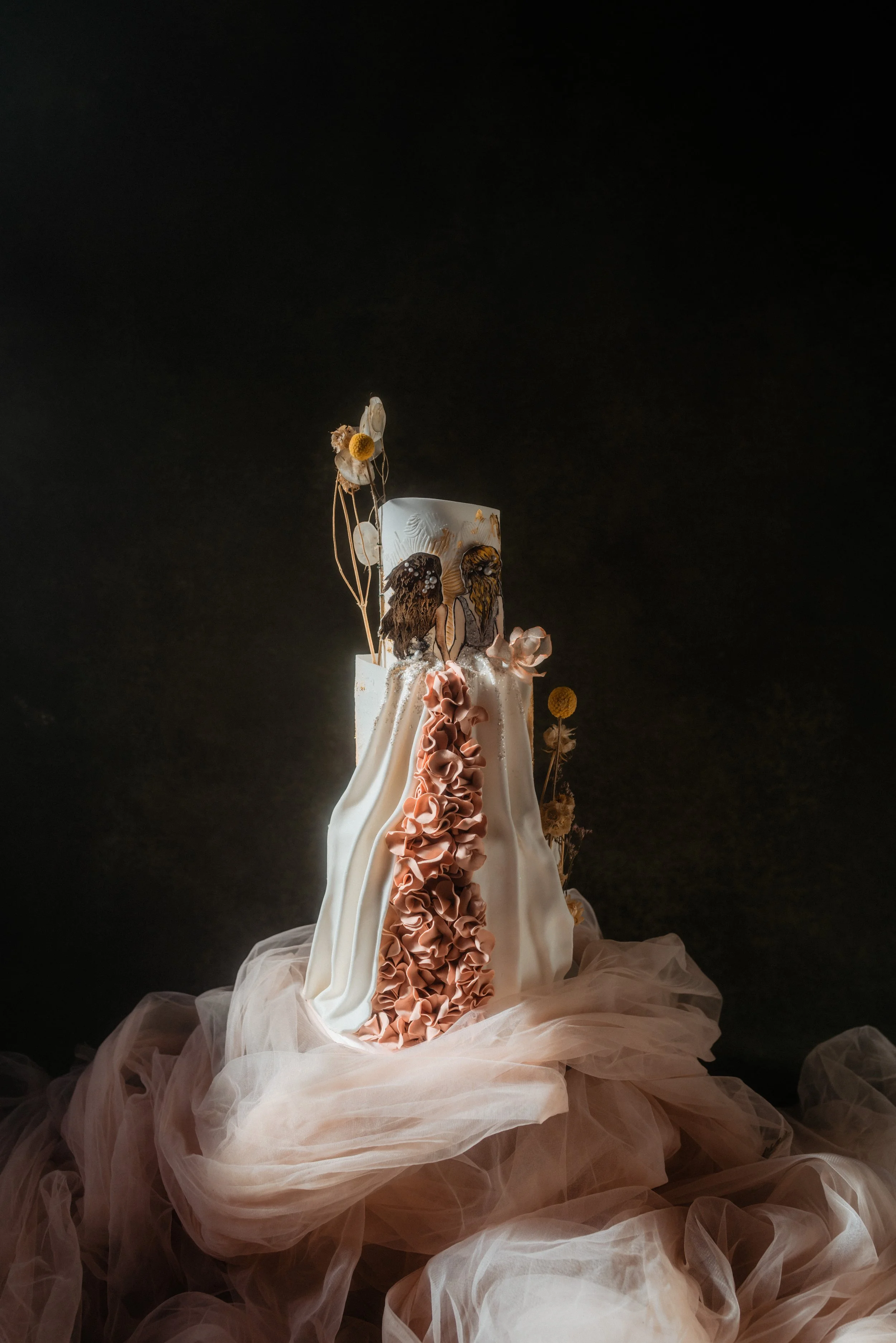 Couture-inspired luxury wedding cake with draped fondant, cascading handmade sugar ruffles and botanical details, styled for an editorial wedding shoot.