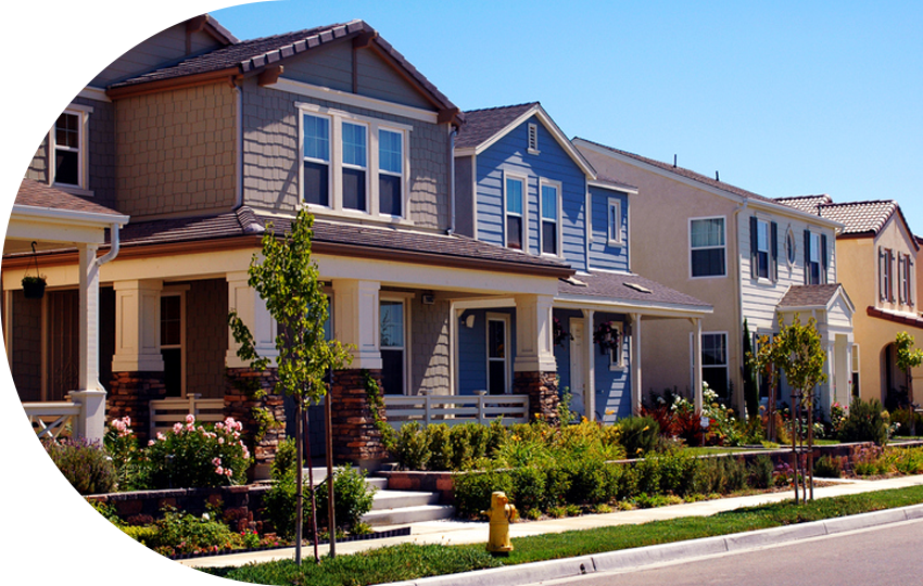 A photograph depicting a neighbourhood full of two-story houses and flowers.