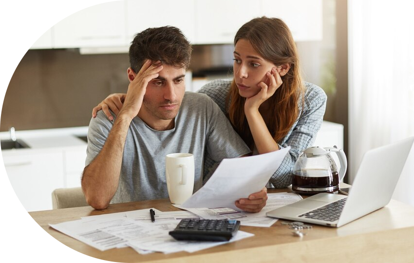 A photograph depicting a man looking at a paper with a frustrated expression, with a woman comforting him with a concerned look on her face.