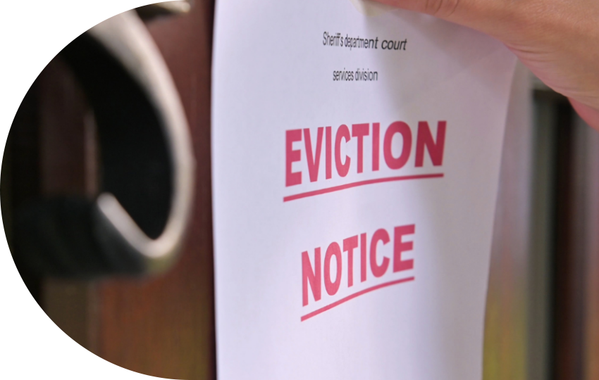 A photograph depicting a piece of paper that says “Eviction Notice” hung up on a door.
