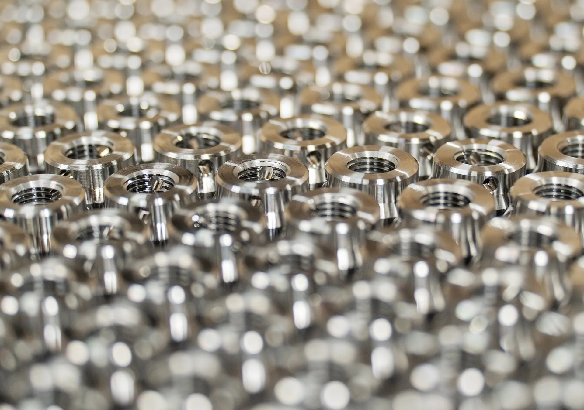 Närbild av många små metallringar, sannolikt lager eller mekaniska delar, glansiga och organiserade i en tät samling.