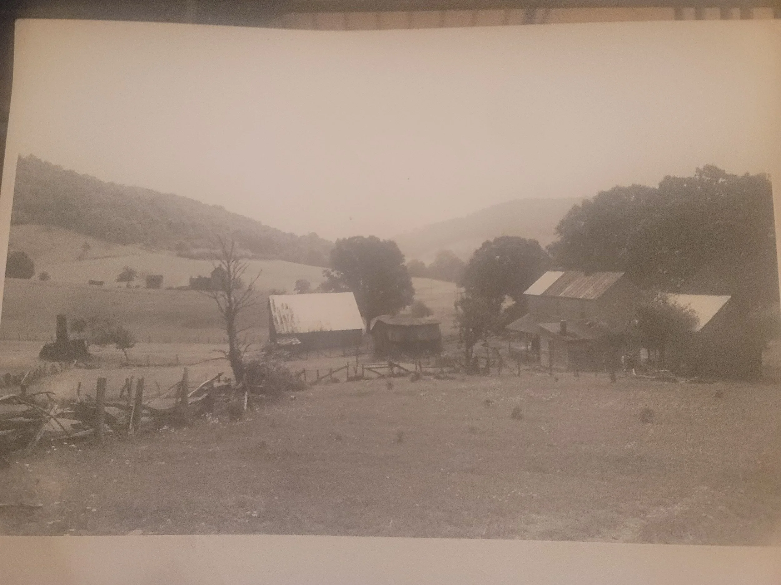 Back and White Photo of the Old Koontz Farmhouse and Homestead.  On the hill in the backdrop is the Kelley Homestead.
