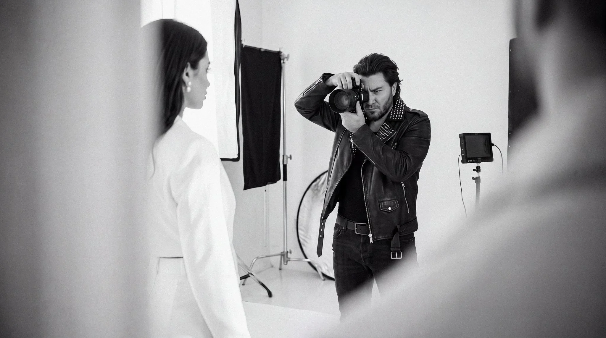 Black-and-white behind-the-scenes image of Dragos Enache photographing a model in a professional studio