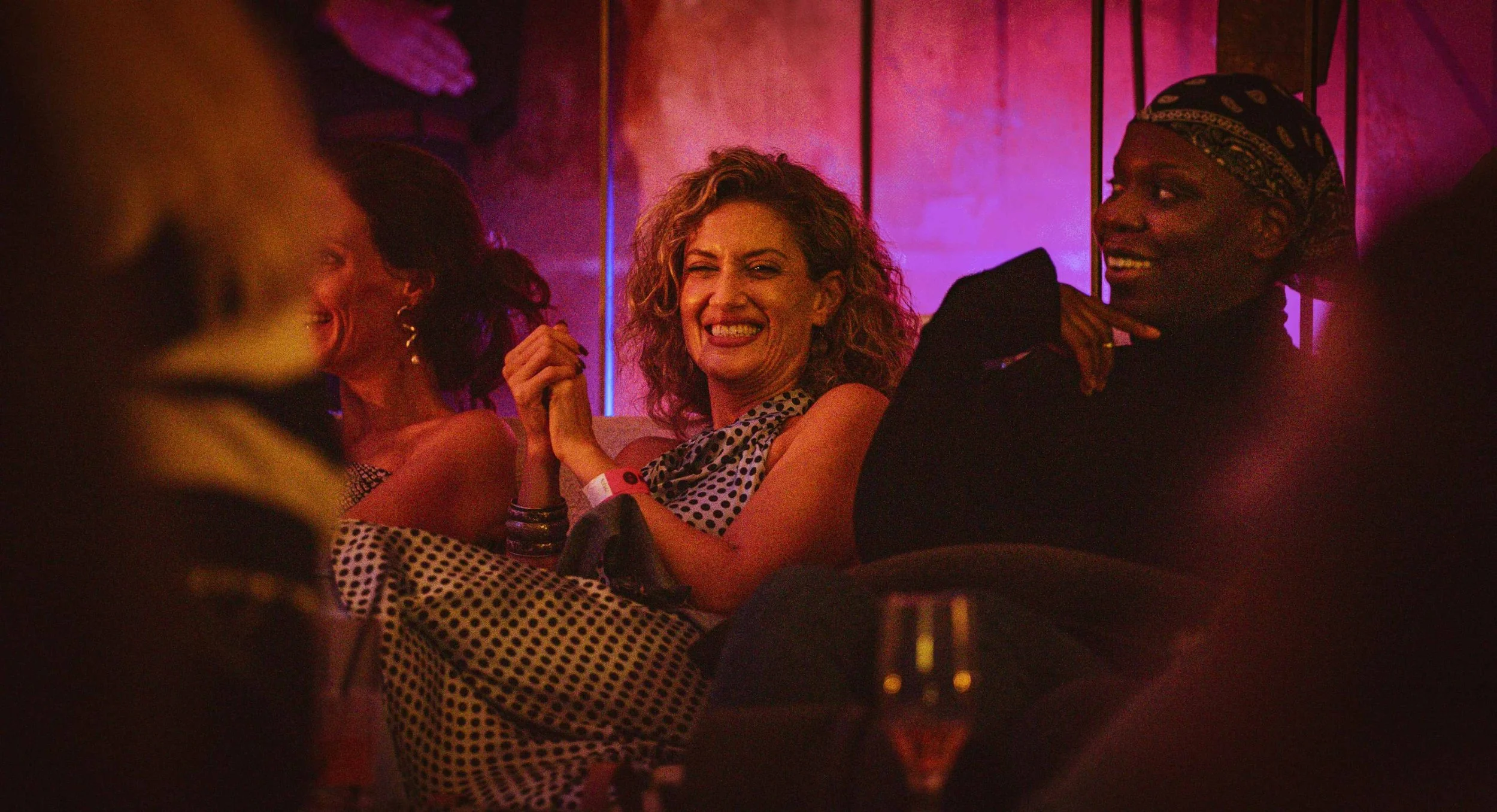 An audience member at RAW smiles as a woman next to her also joins in the sense of joy
