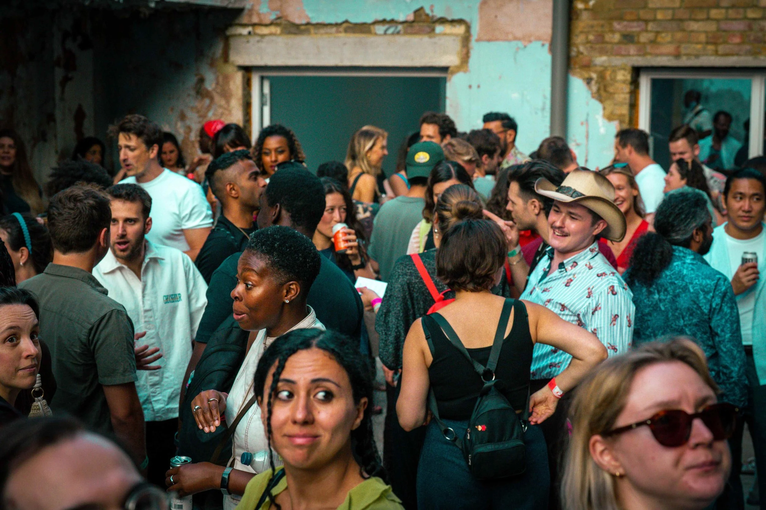 A very diverse group of humans in a yard at a RAW uncensored storytelling night in London