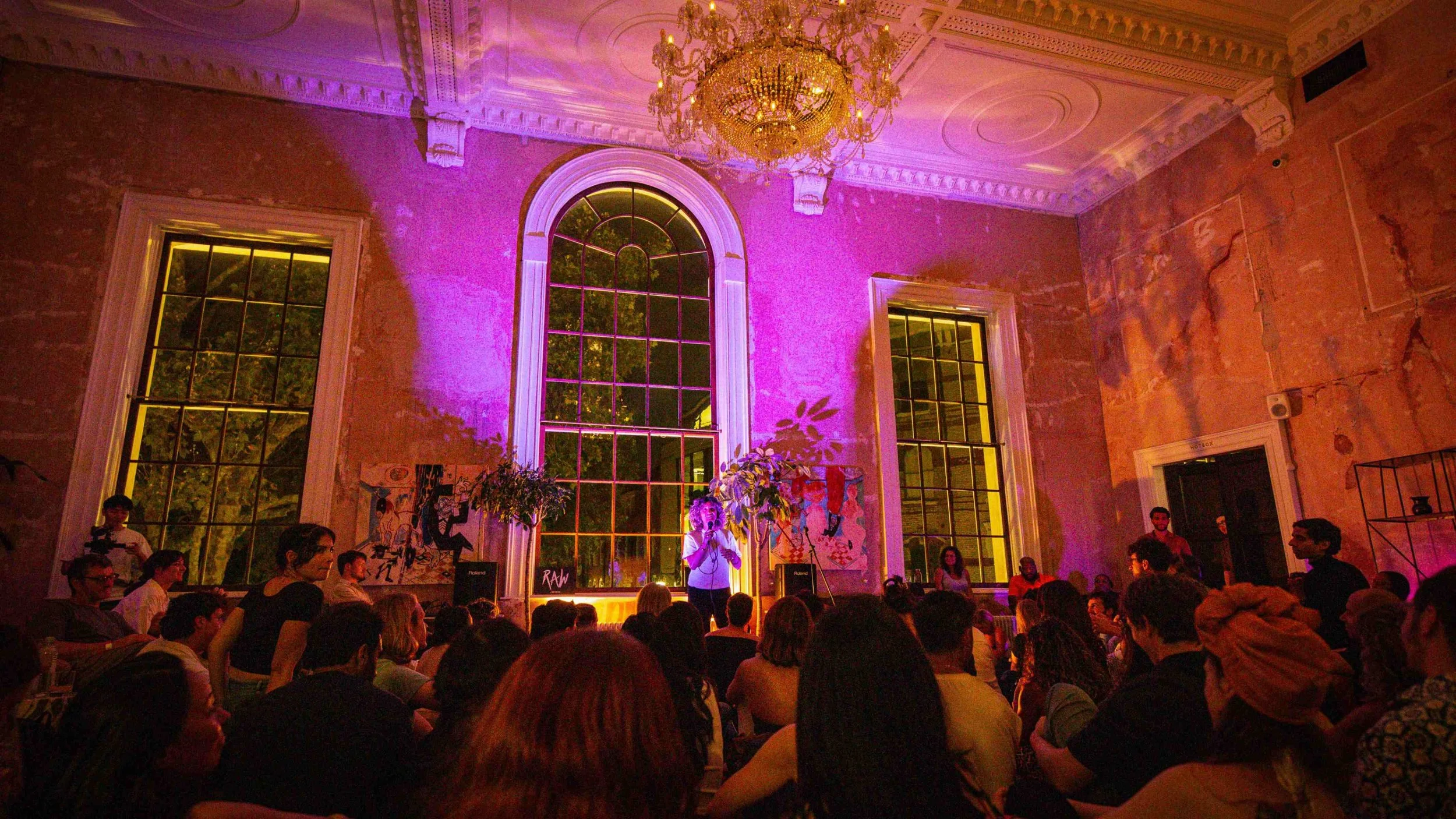 Audiences at a RAW uncensored storytelling in London sit on the floor and listen as they are welcomed into the RAW storytelling space
