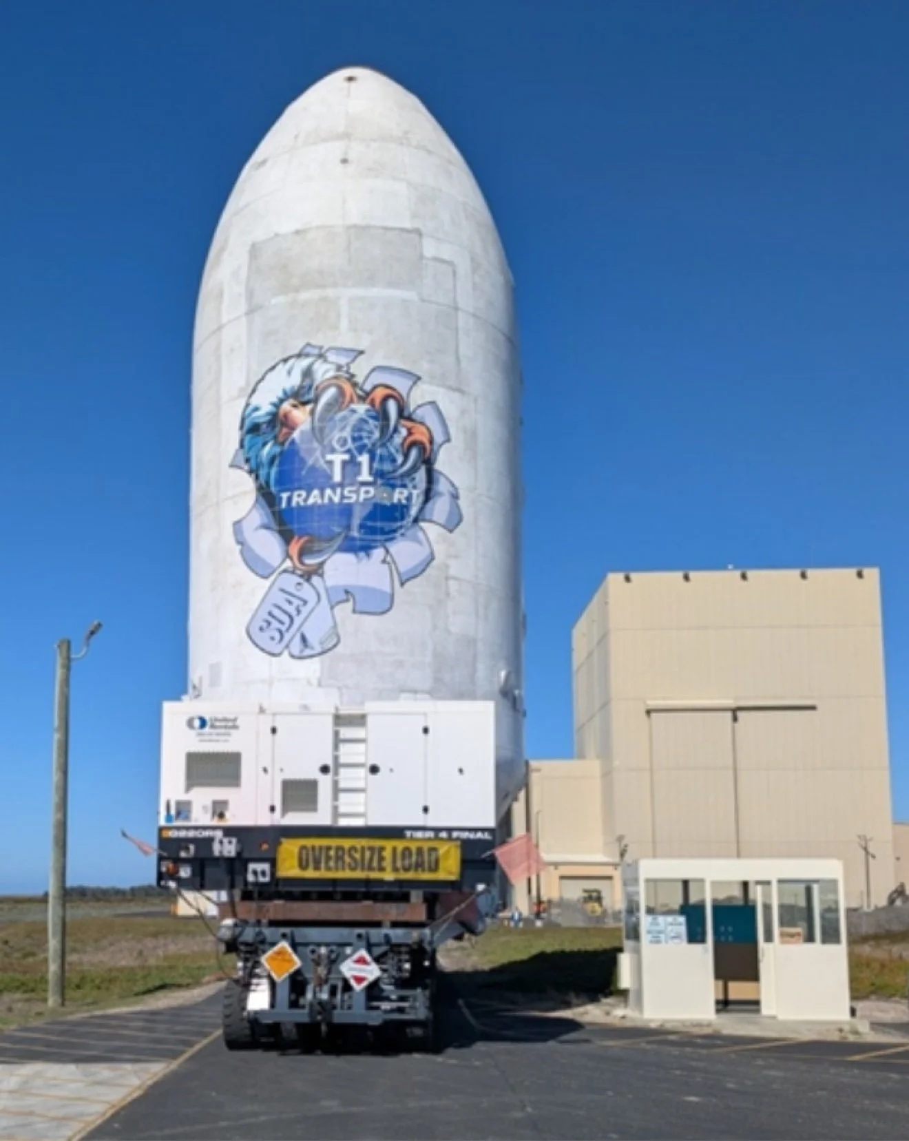The fairing on its transporter — oversize load, rolling to the pad