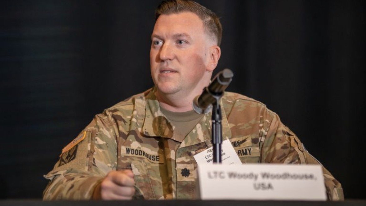 Mike “Woody” Woodhouse speaking on a defense panel during his U.S. Army service.
