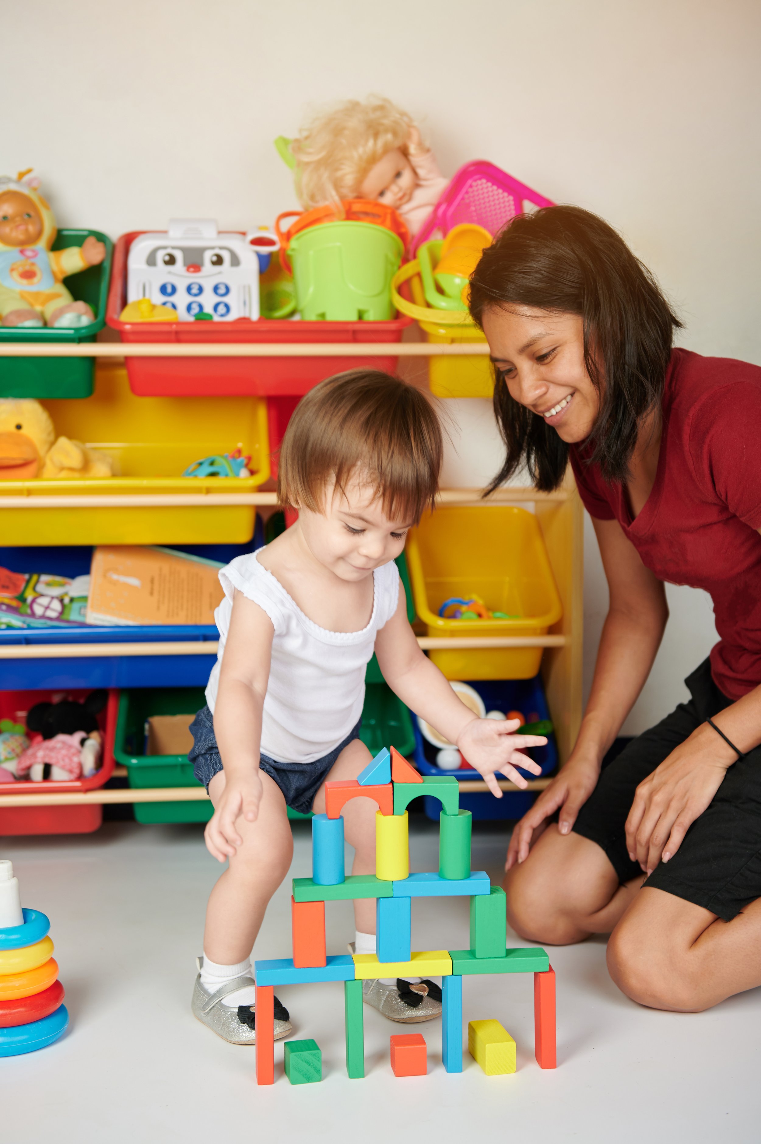 Mom and child building with blocks in playroom