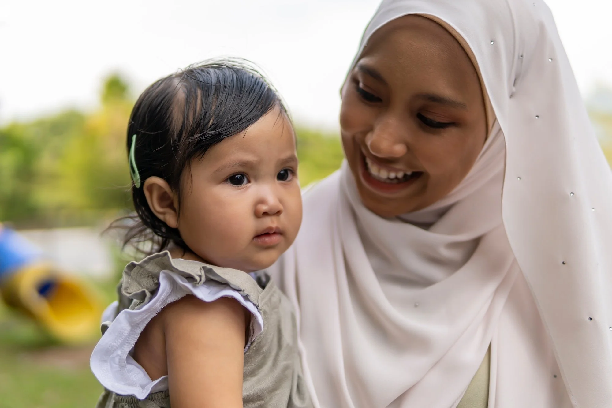 Mother holding daughter and smiling