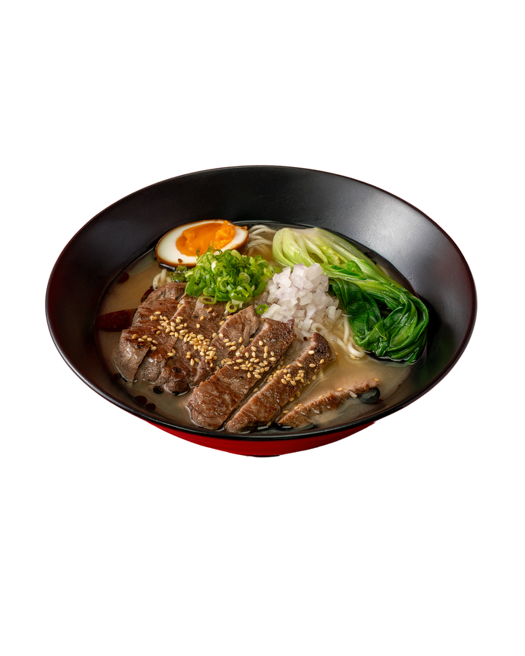 Bowl of ramen with sliced beef, soft-boiled egg, chopped green onions, shredded white onion, bok choy, and noodles in broth.