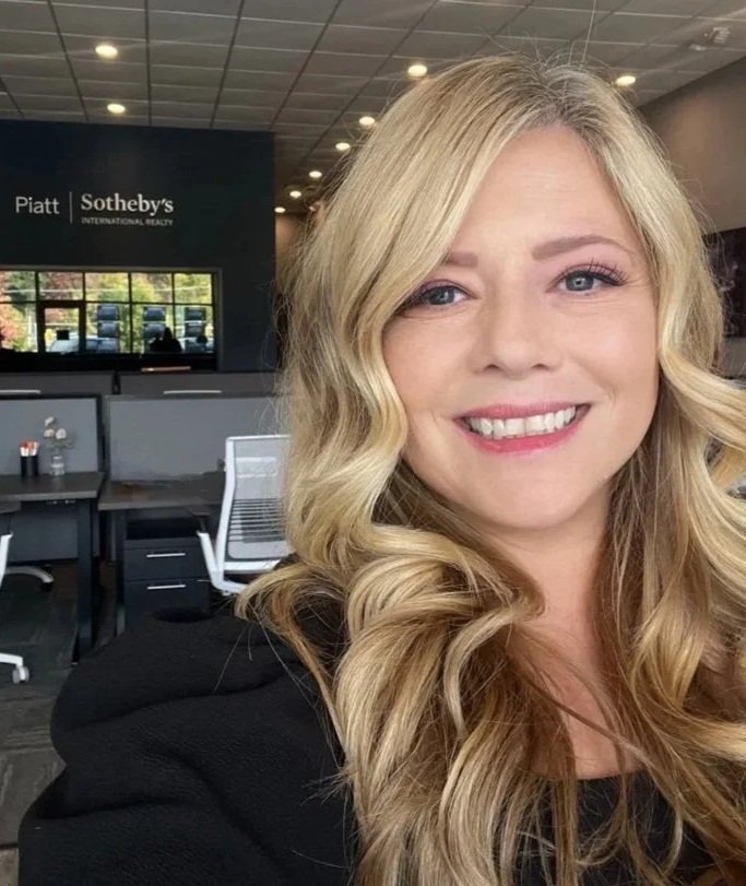 local real estate agent in office with friendly smile