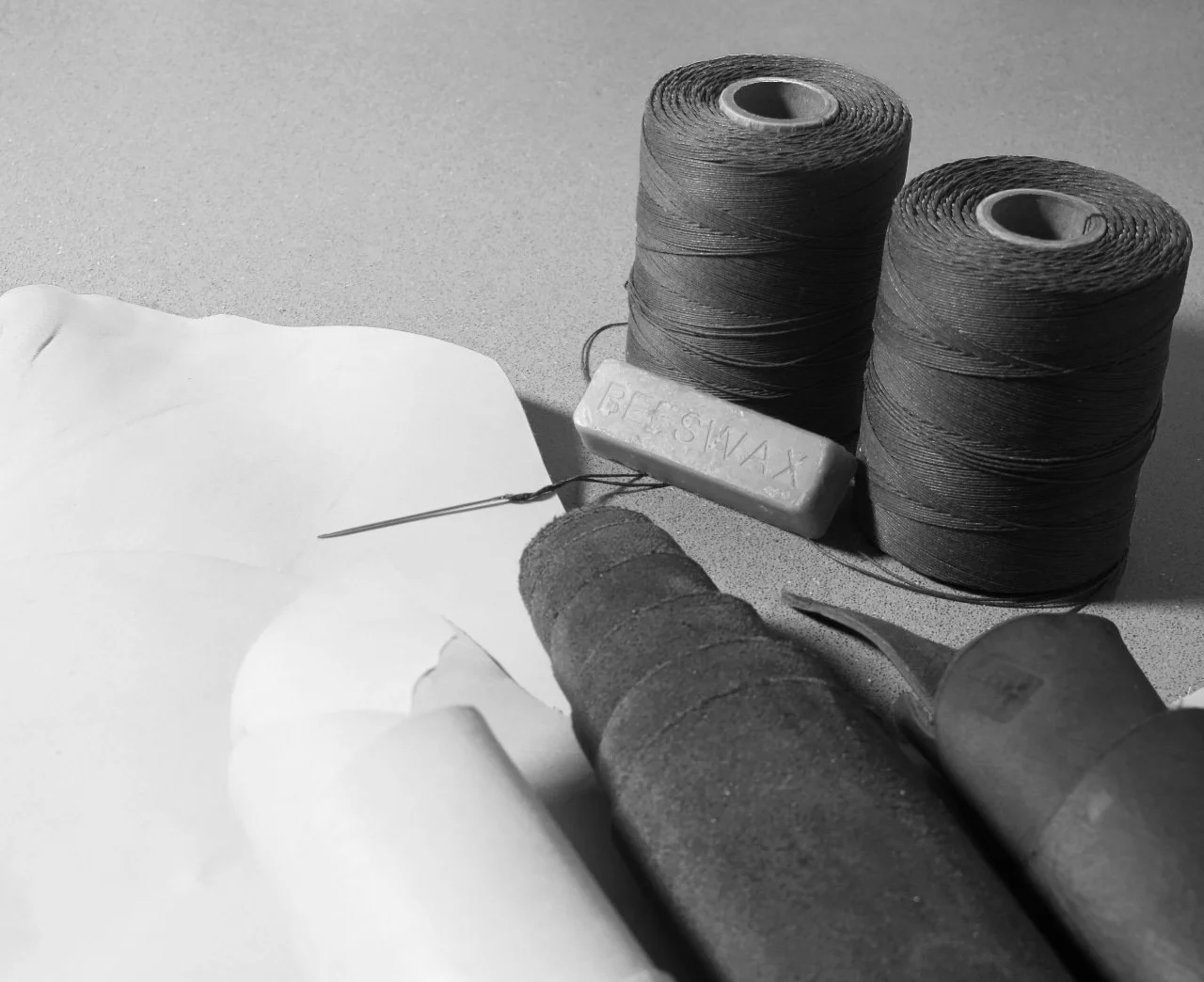 Collection of leather working materials, leather threads and beeswax.