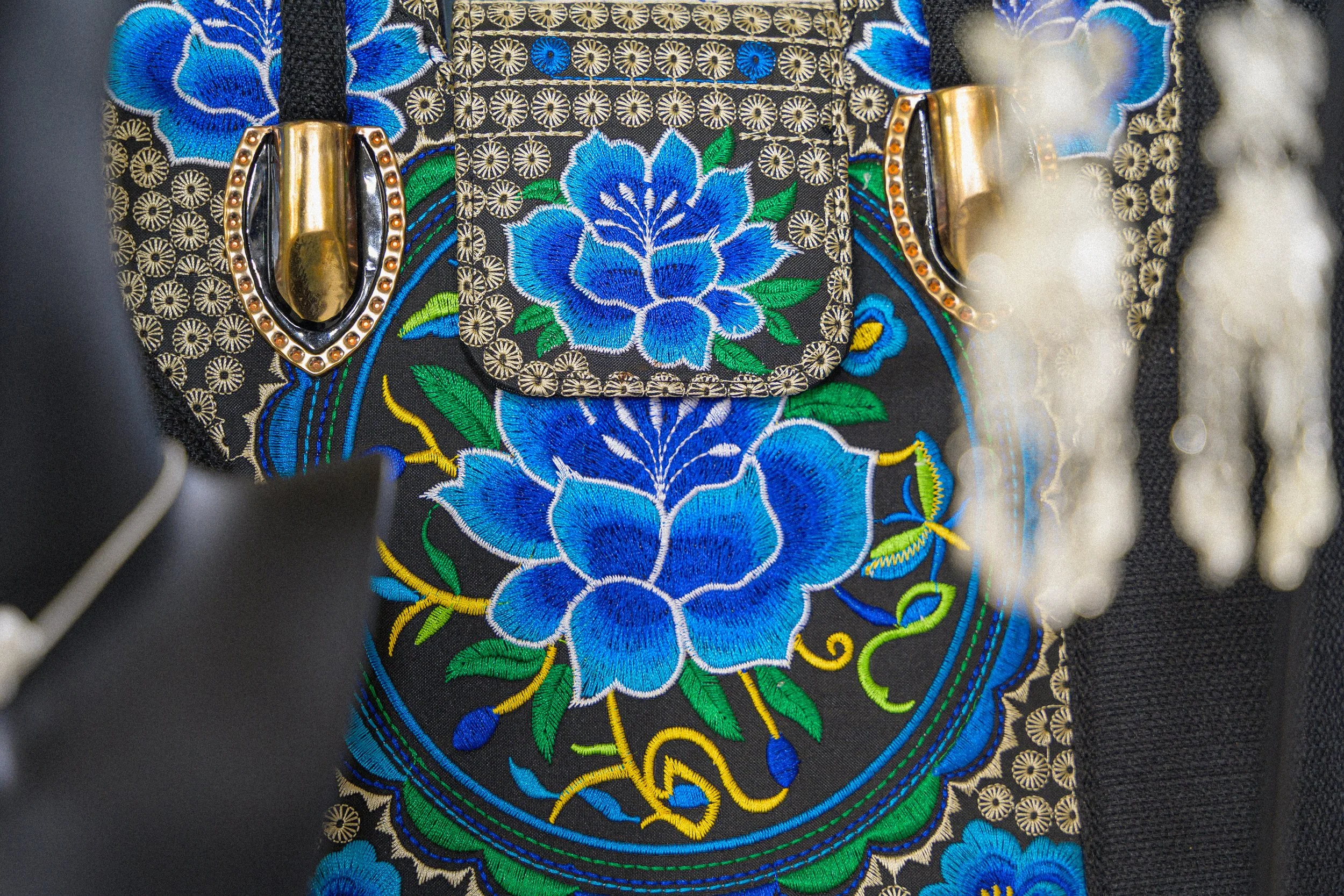 Close-up of hand-stitched blue floral embroidery on traditional Chinese textile
