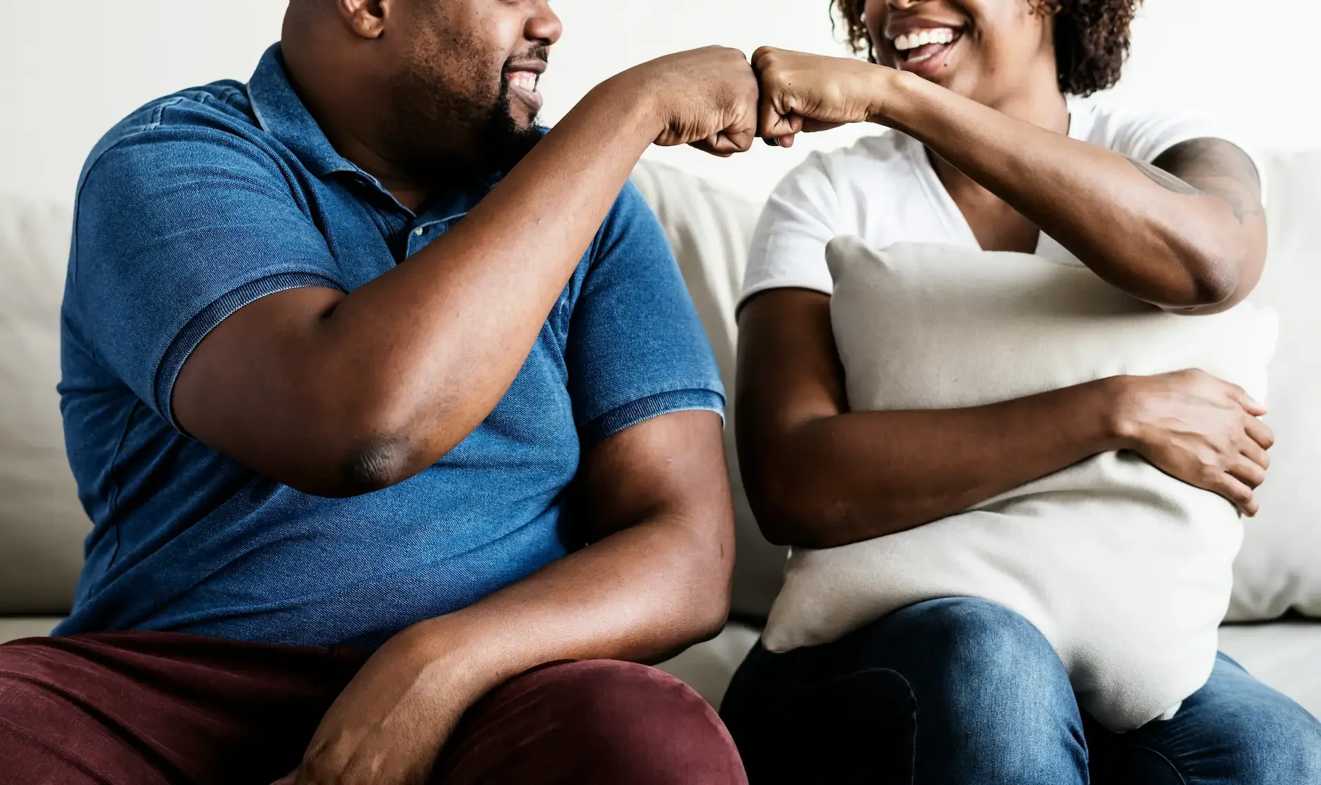 Close-up of man and woman smiling and fist-bumping
