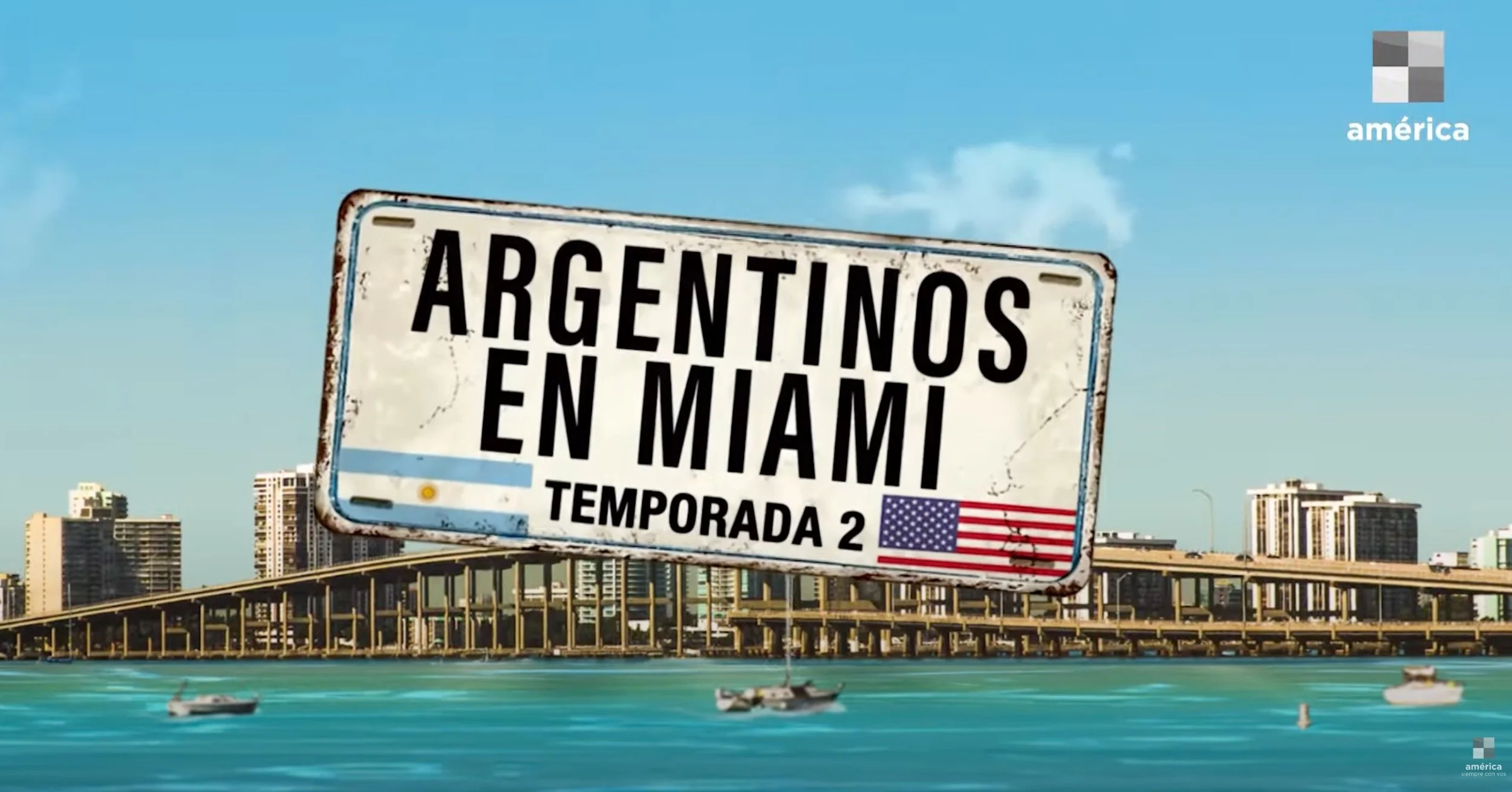An aged, tilted road sign in the Miami skyline reads, "Argentinos en Miami, Temporada 2," with the American flag. Water with boats is in the foreground, and tall buildings with a bridge are in the background.