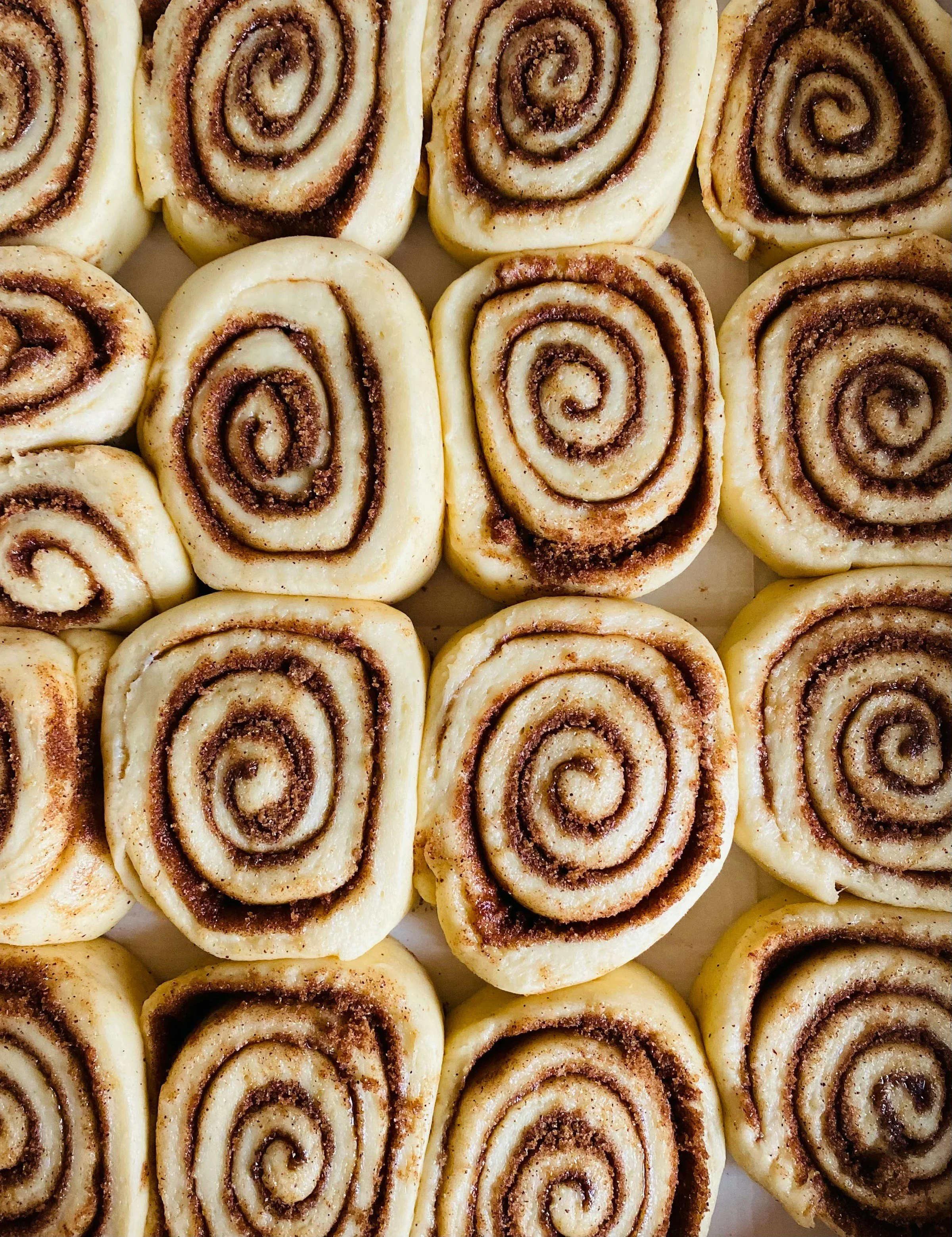 Close-up of several cinnamon rolls with swirled cinnamon filling.