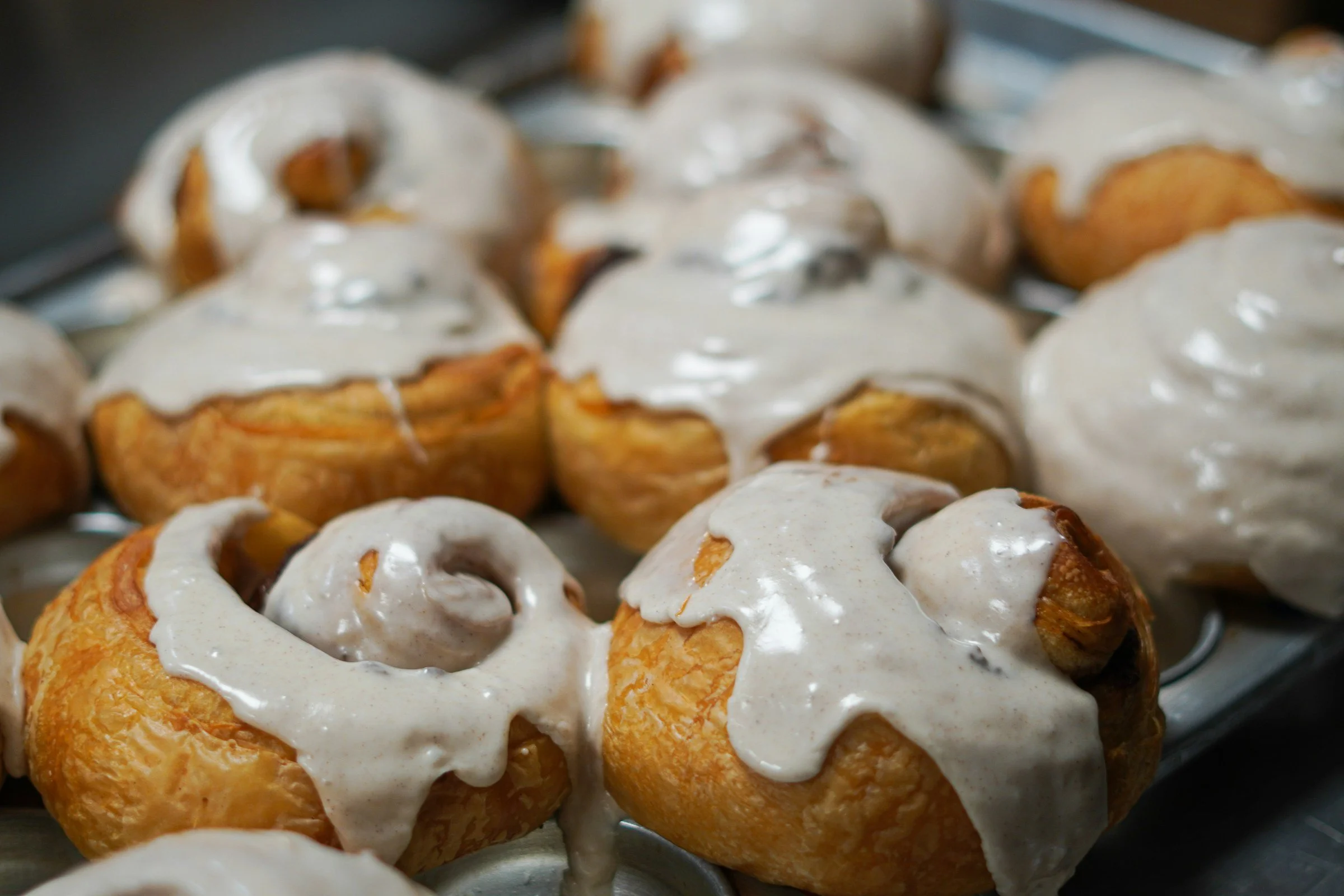 Close-up of cinnamon rolls topped with white icing.