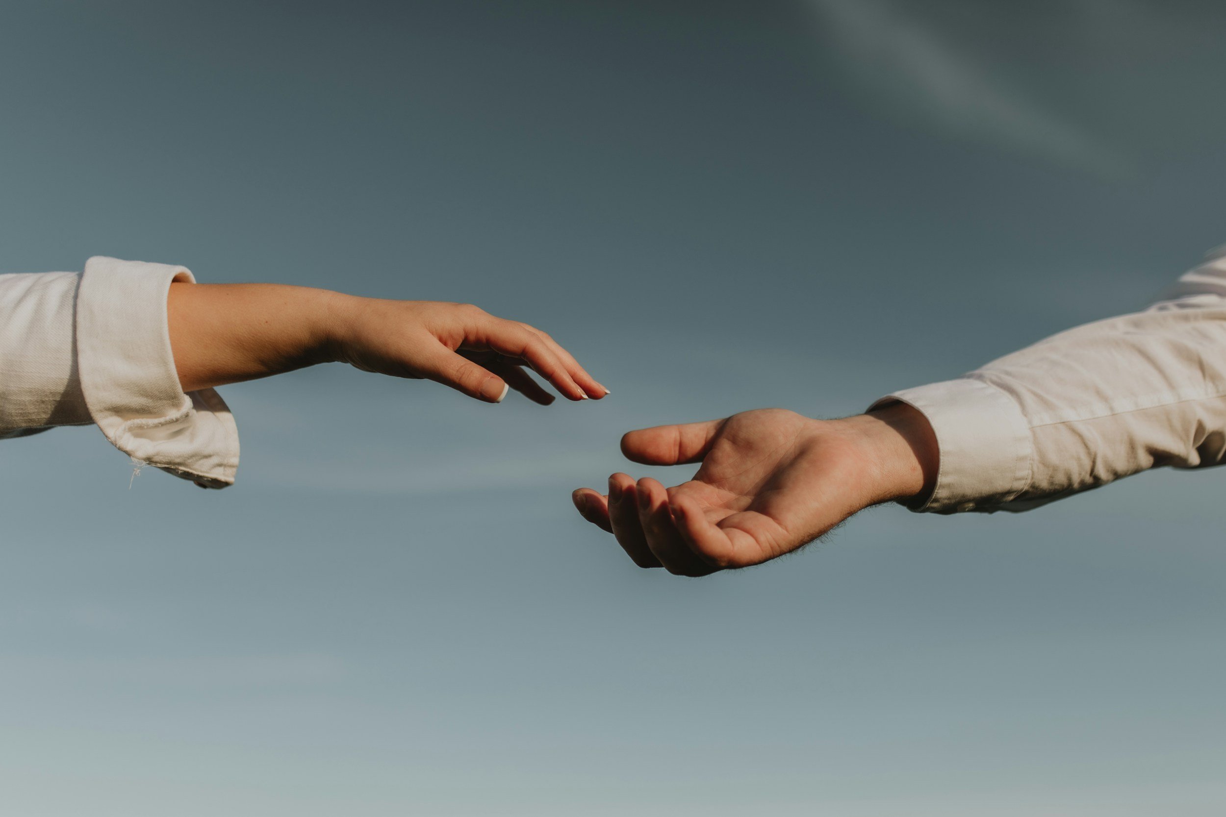 Two hands reaching towards each other providing support and accountability