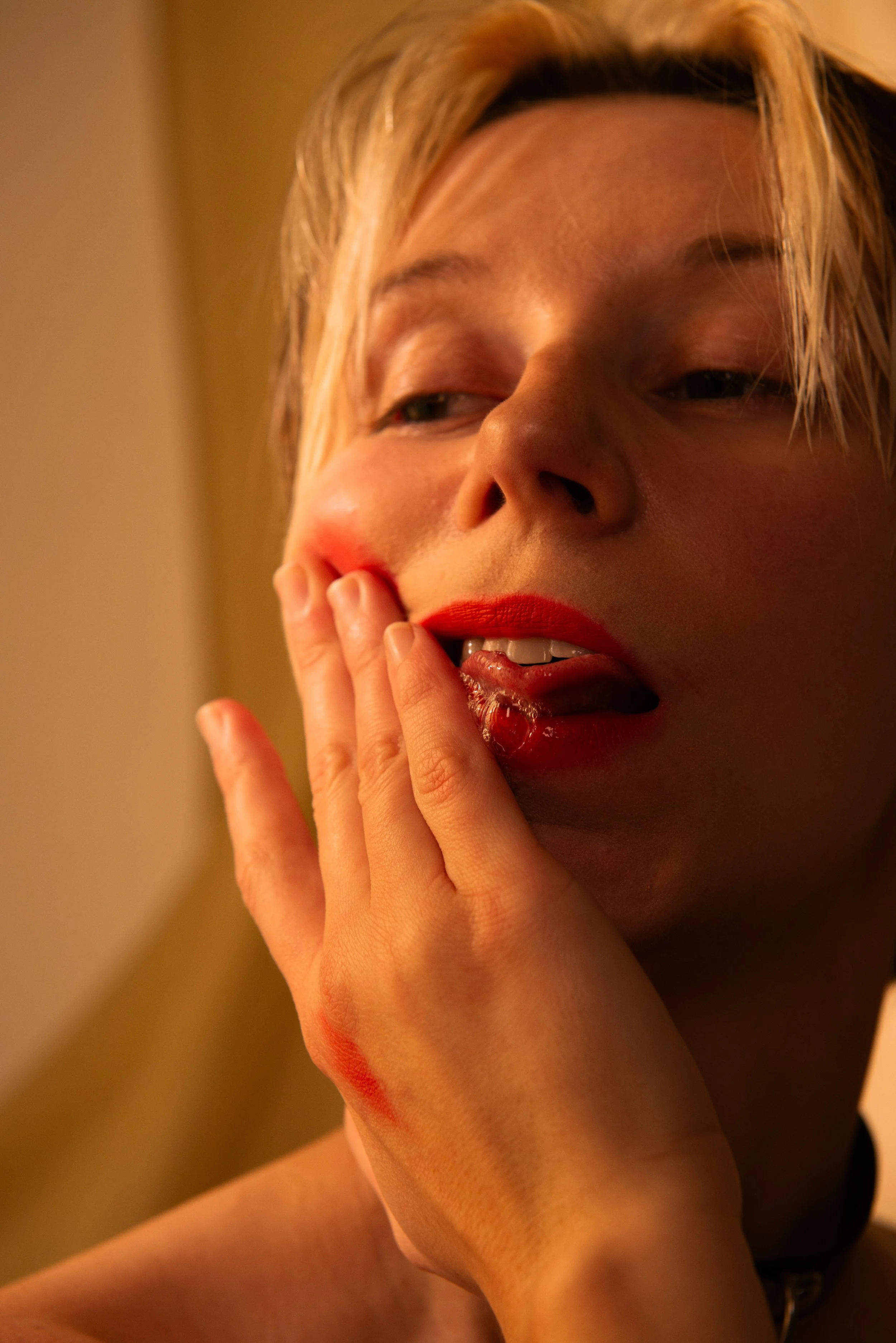 Person touches their face and looks into distance with spit on their tongue