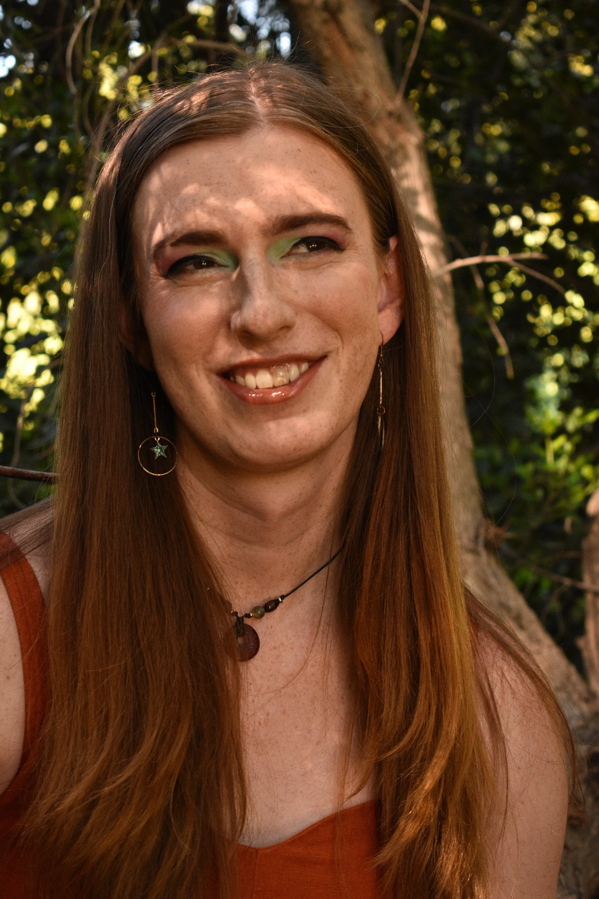 Person in dappled shade smiles