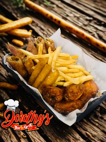 Basket of fried chicken wings, French fries, and fried cheese sticks on a wooden table, with a logo for Dorothy's Bar & Grill.