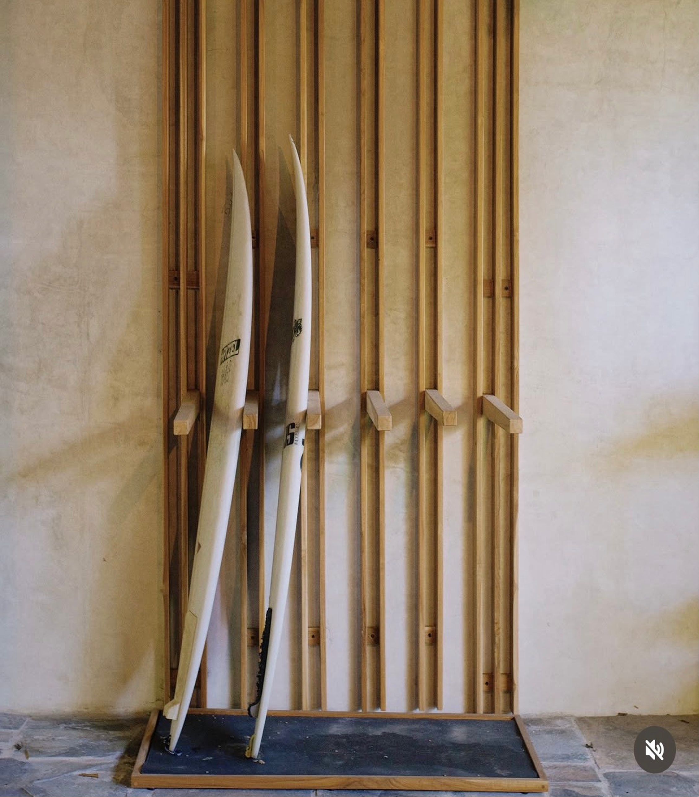 Interior wall with unfinished wooden framing and three surfboards leaning against the wall. The setting appears to be a construction site or renovation in progress.